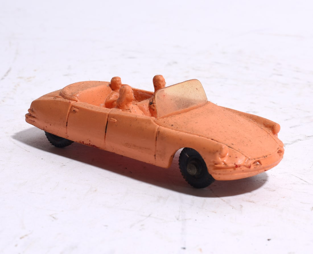 Plastic Convertible Passenger Car with Figures: Mid-century molded plastic convertible passenger automobile with three seated figures. Finished in peach-colored plastic with rolling wheels and light play wear.