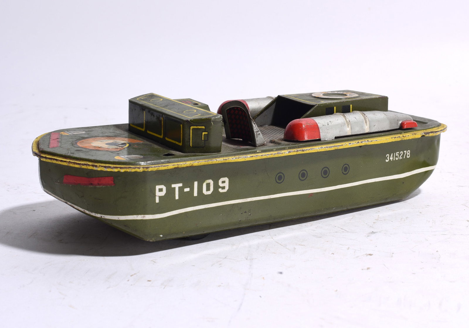 PT-109 Tin Lithograph Military Patrol Boat: Tin lithograph military patrol boat marked "PT-109." Features olive green finish with deck details and cabin structures. Showing age-related wear, scratches, and paint loss.