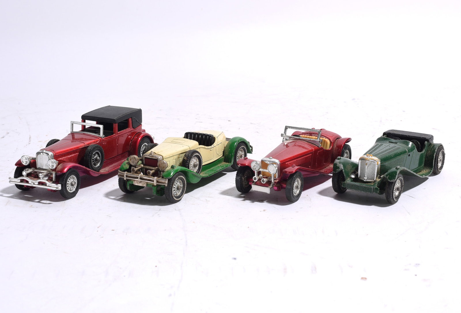 Assorted Die-Cast Convertible and Touring Car Group: Group of four die-cast vintage automobile models including convertibles, roadsters, and touring cars. Detailed scale reproductions with painted finishes and chrome accents. Showing light to moderate w