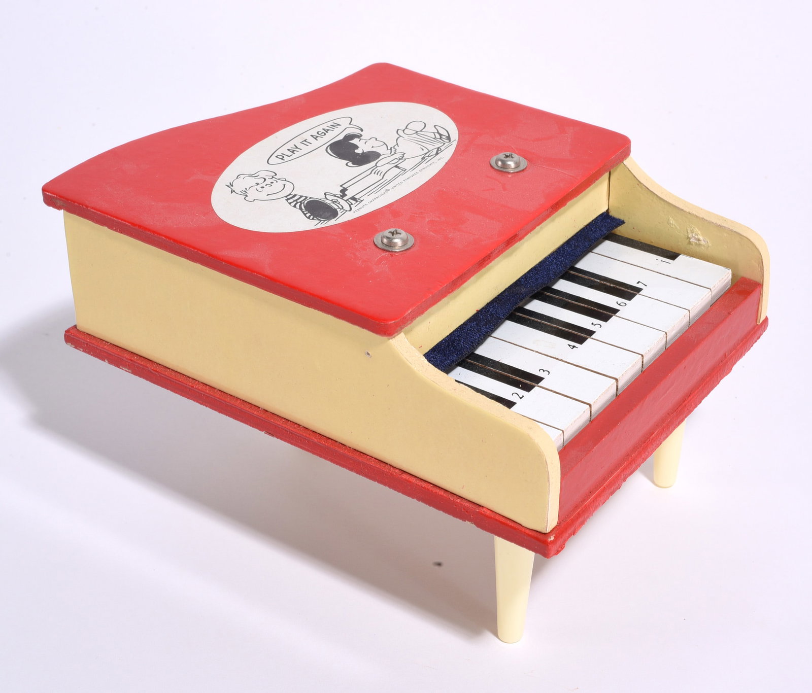 Peanuts Themed Toy Piano: Child's toy piano with red and cream painted case featuring Peanuts character graphics and "Play It Again" decoration. Includes keyboard and four legs. Moderate wear from use.