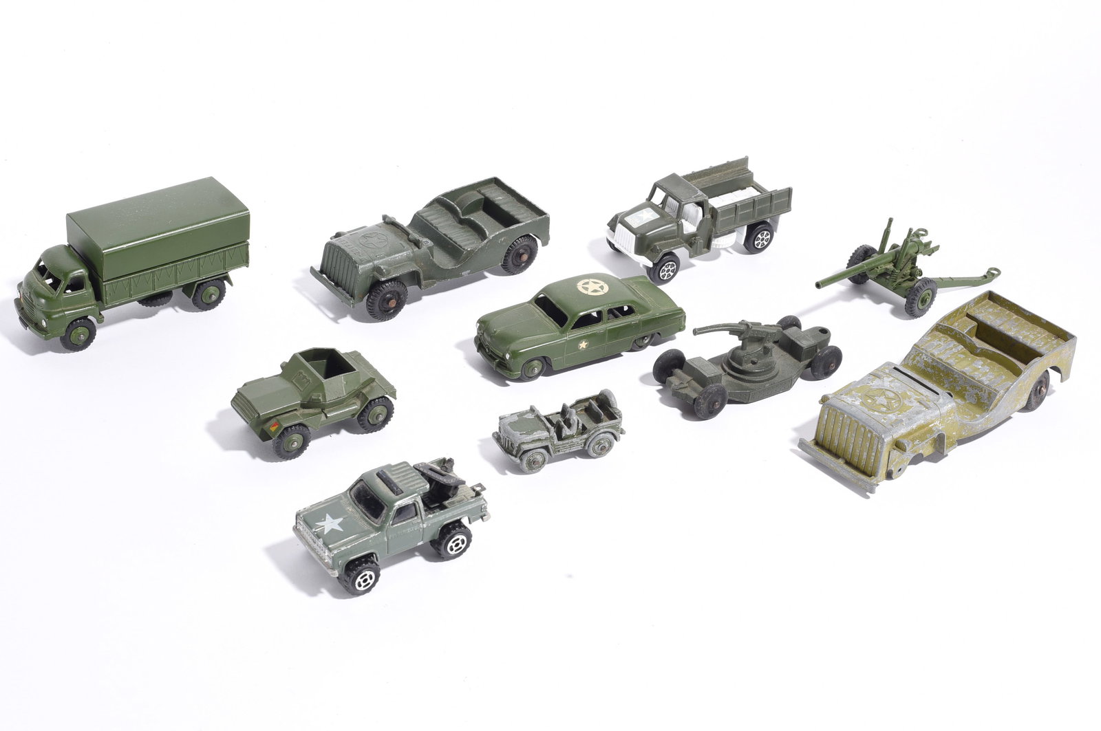 Assorted Military Toy Vehicle Collection: Group of military-themed toy vehicles and accessories including trucks, jeeps, artillery pieces, armored vehicles, and staff cars. Mixed makers and scales with varying degrees of wear and use.