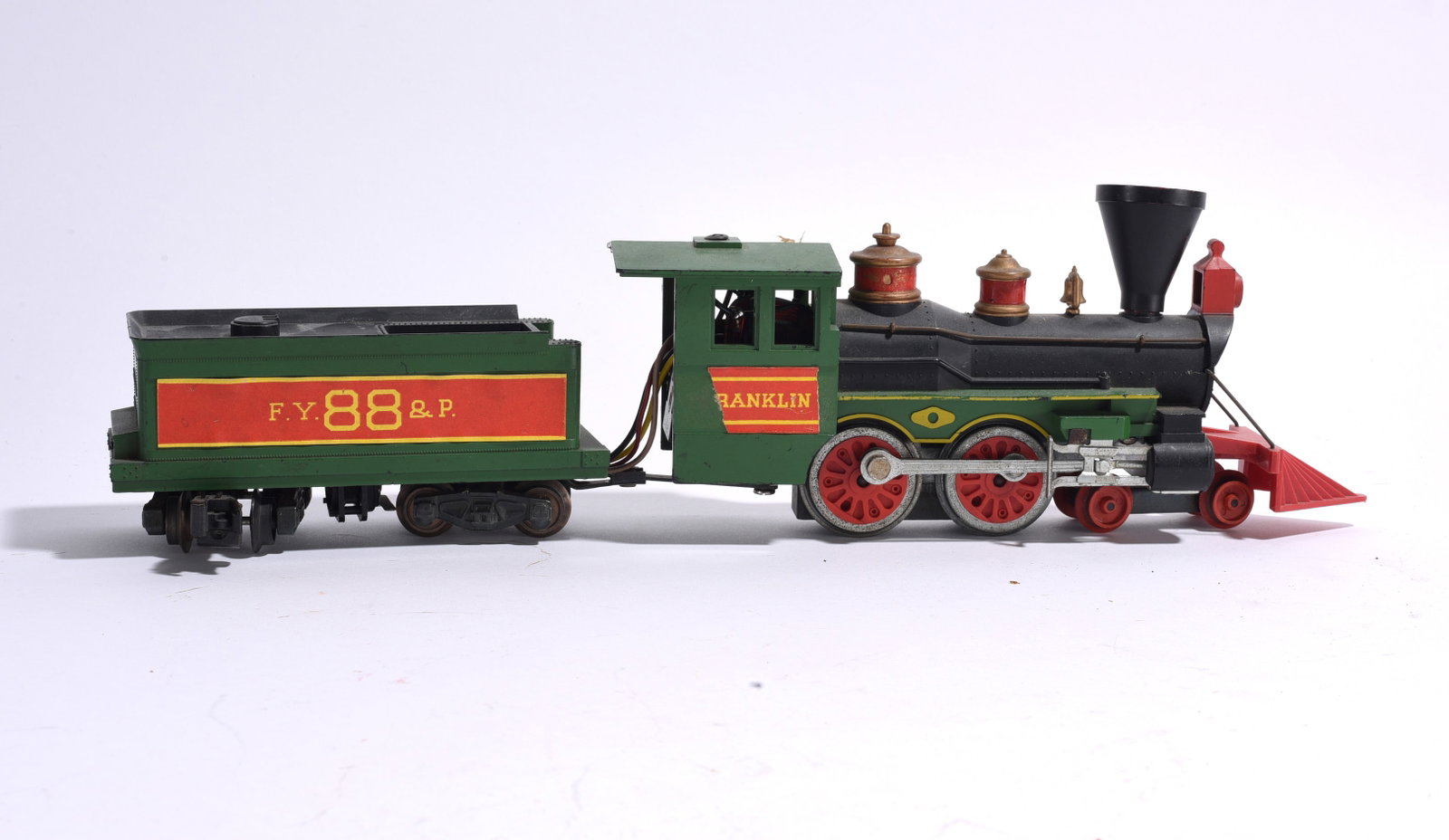 Franklin Toy Train Locomotive and Tender: Franklin steam locomotive and matching tender in green, red, and black painted finish. Features electric operation and decorative detailing. Showing expected age-related wear.