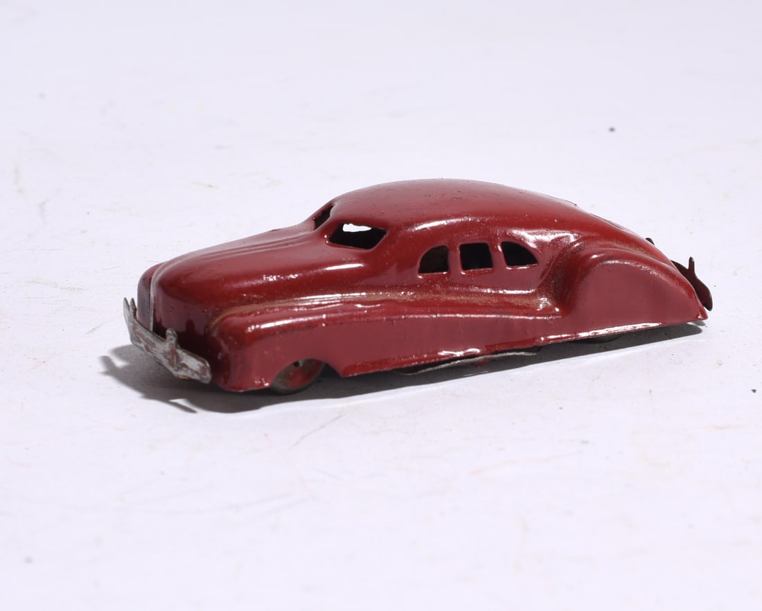 Plastic Sedan Automobile: Plastic toy sedan in light blue finish with yellow wheels and molded body details. Retains original form with age-related wear and surface marks.