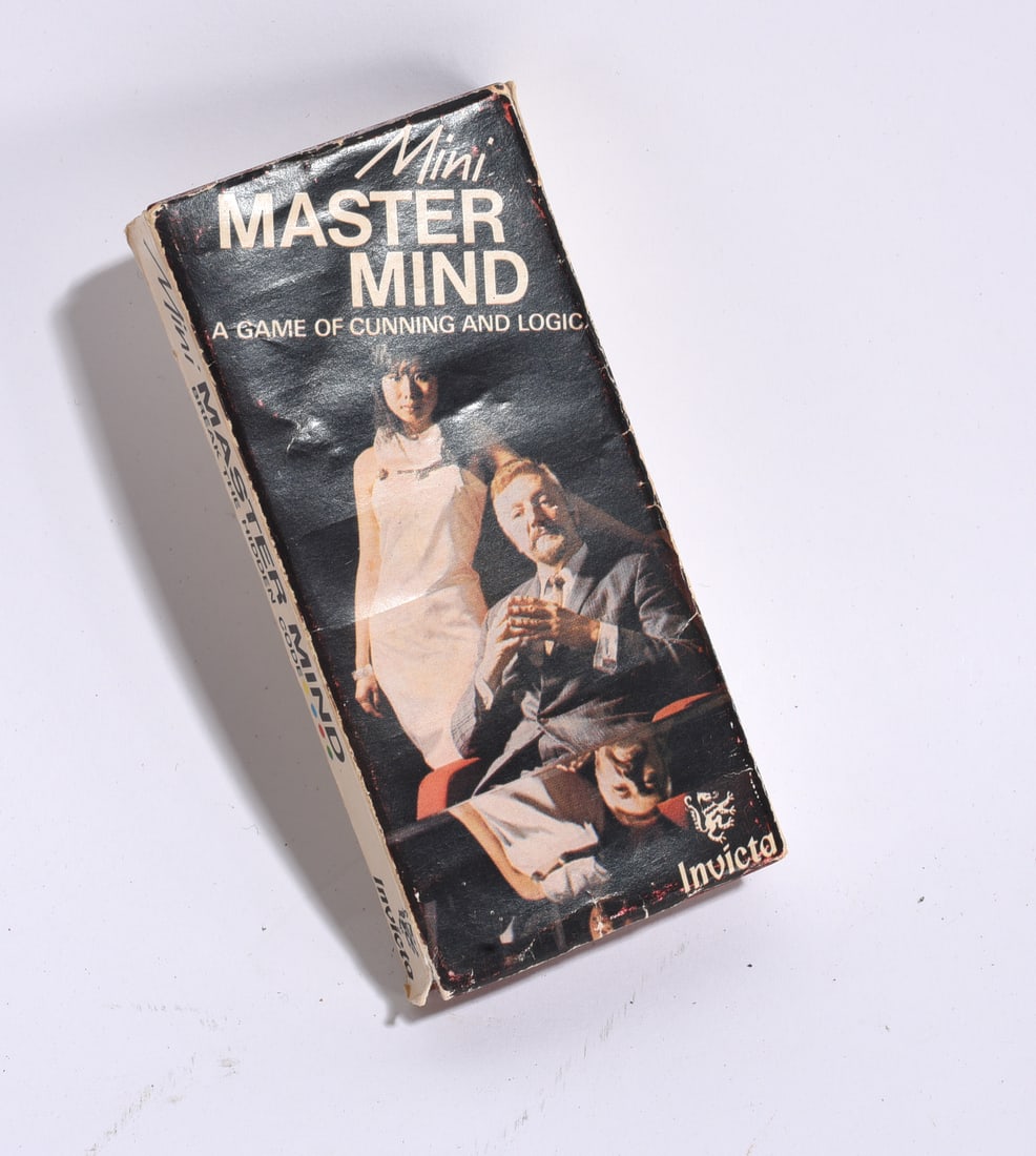 Invicta Mini Master Mind Travel Game: Vintage Invicta Mini Master Mind travel game, a compact version of the popular code-breaking strategy game. Includes original box with visible shelf wear and handling marks.