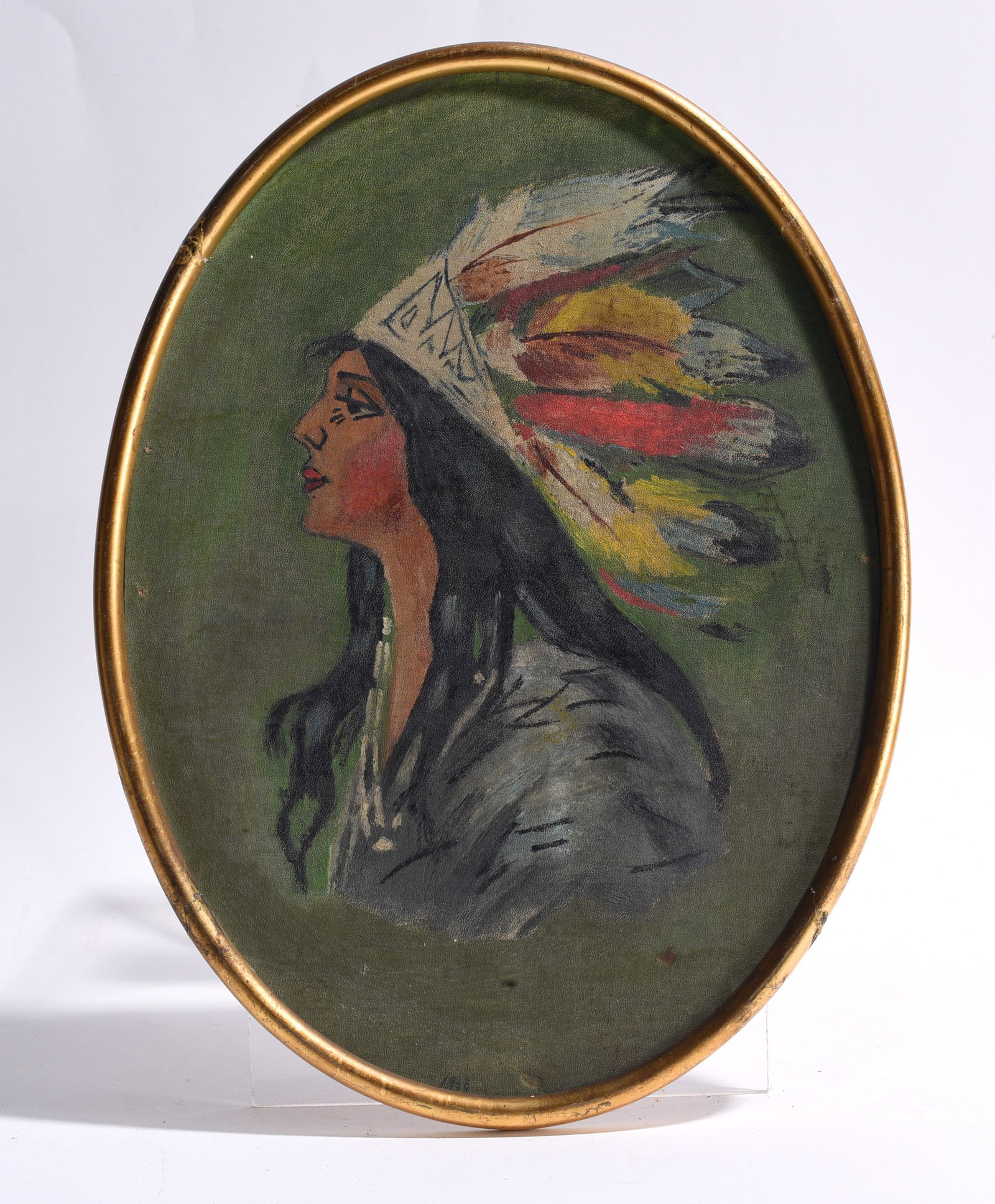 Portrait of Native American Woman Oil on Canvas: Oil on canvas portrait depicting a Native American woman in profile wearing a feathered headdress and bead necklace, housed in an oval gilt frame. Decorative twentieth-century portrait with bold color