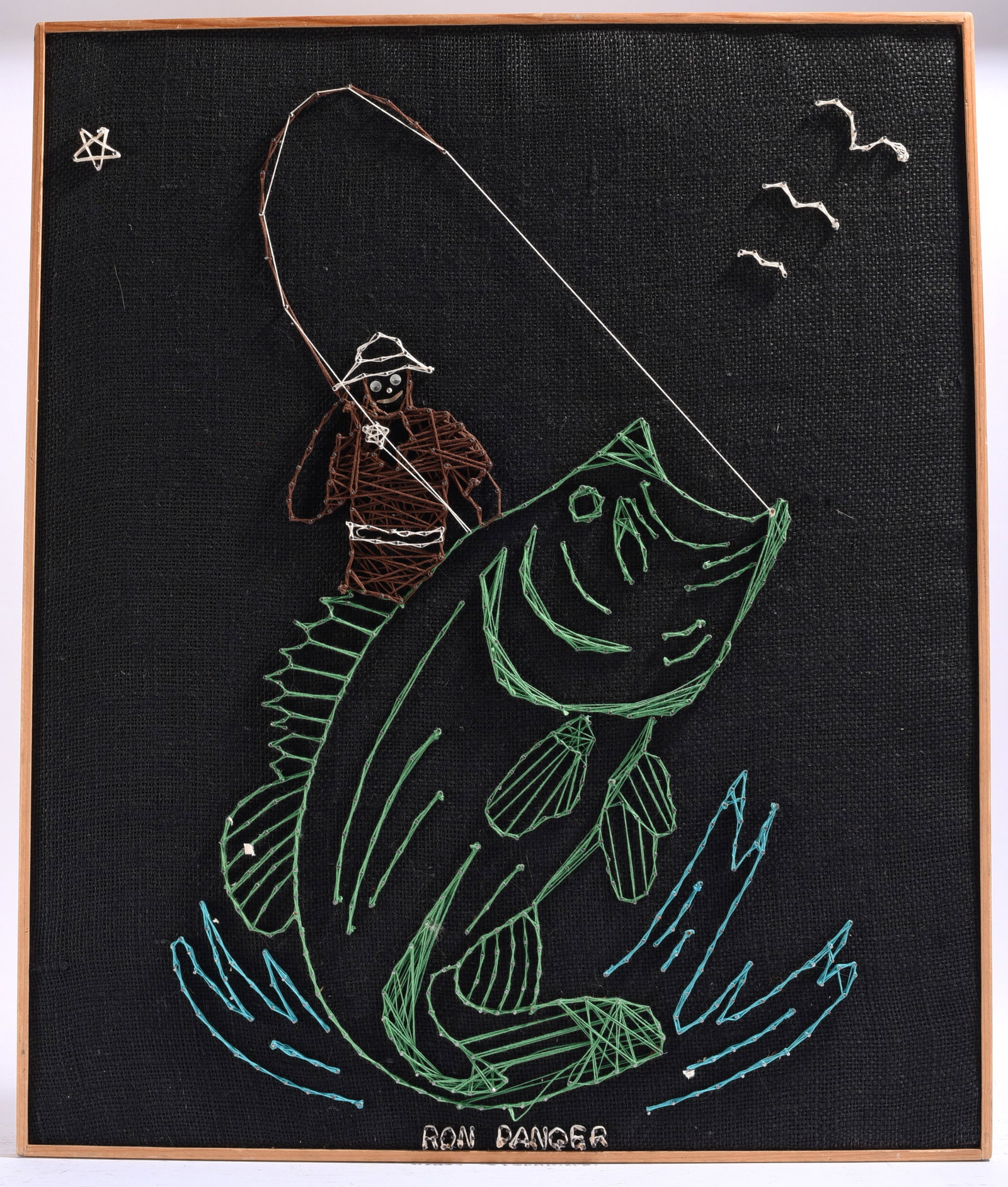 Ron Danger String Art Fishing Scene Signed L.J.Panger On Back: 20.5"x24.5" Handcrafted string art by L.J.Panger depicting an angler landing a large fish. Created with colored thread on a black fabric ground and mounted in a wood frame.