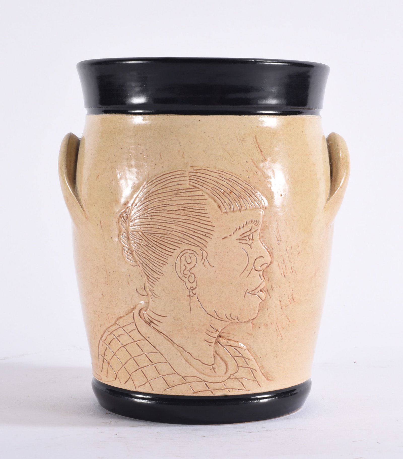 Winton and Rosa Eugene Folk Pottery Jar: 8" Large cylindrical folk pottery jar with light tan body, black glazed rim and foot, applied side handles and an incised profile portrait decorating the front.