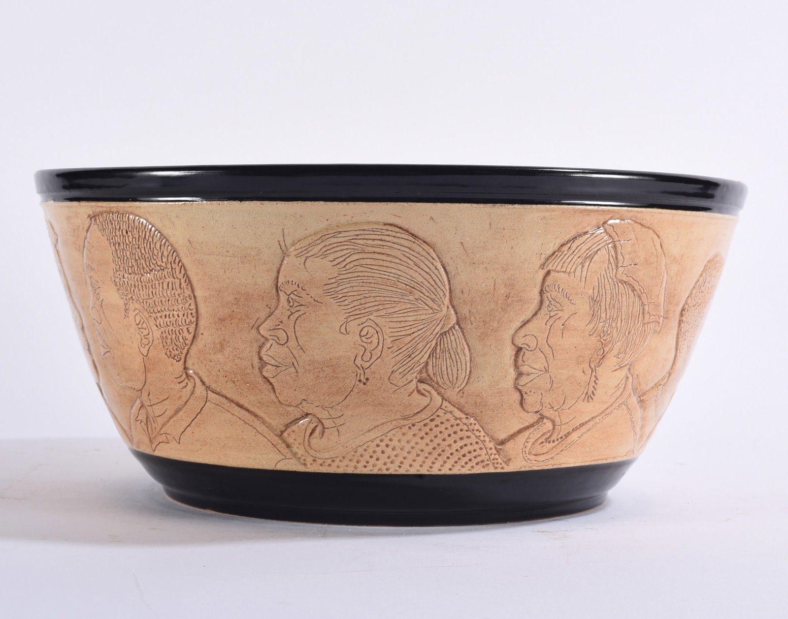 Winton and Rosa Eugene Folk Pottery Bowl: 6"x12" Large folk pottery bowl with light tan body and contrasting black glazed rim and foot, decorated around the exterior with finely incised profile portraits.