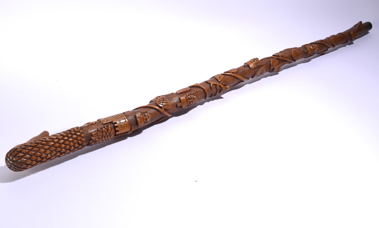 Folk Art Walking Stick ca. 1920: 39" Elaborately carved wooden folk art walking stick with dense relief decoration along the shaft, including animals, figures, tools and geometric motifs, with a textured carved handle.