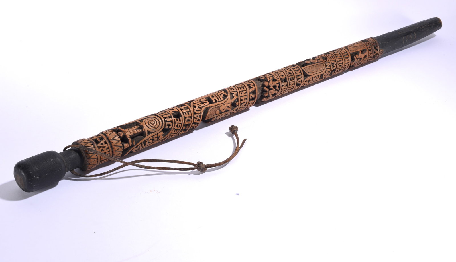 Folk Art Soccer Carved Walking Stick ca. 1963: 36" Densely carved folk art walking stick dated 1963, covered with relief-carved lettering, figures, symbols and decorative bands, with darkened ends and attached leather wrist strap.