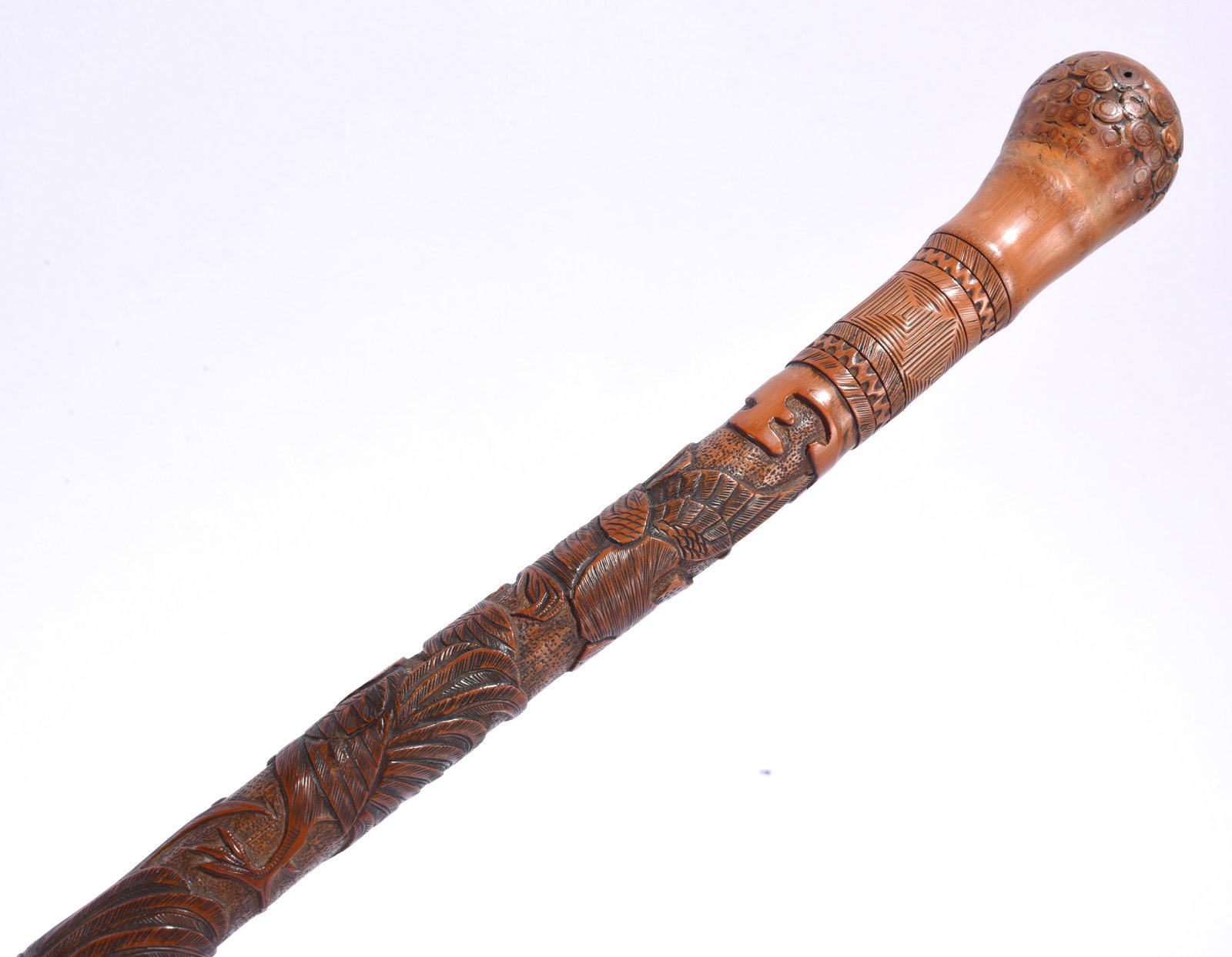 Japanese Folk Art Carved Cane: 36" Japanese folk art carved cane with detailed relief and incised decoration, including birds, foliage and geometric motifs, with a rounded carved grip.