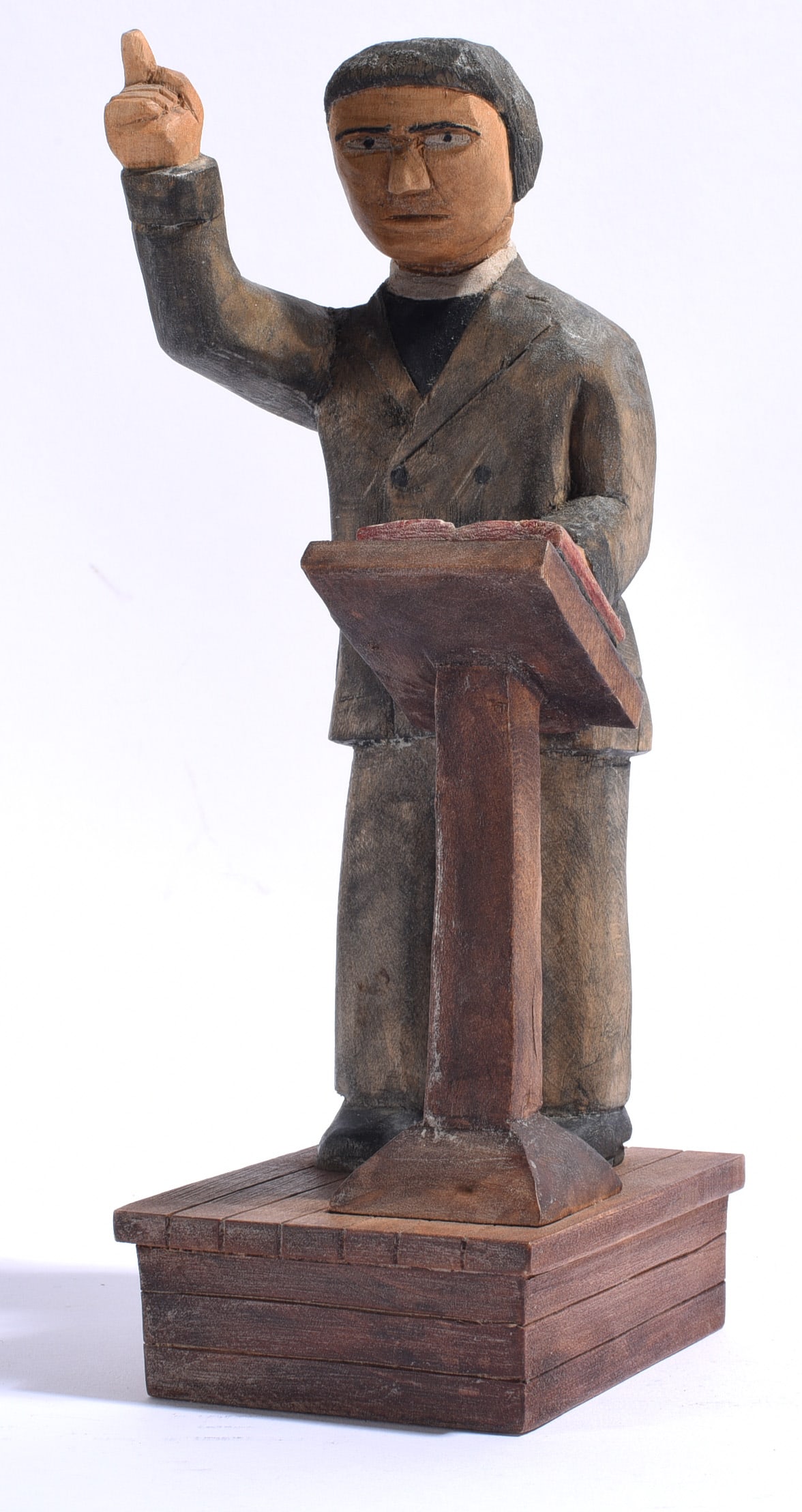 Ray pace Folk Art Carving: 11" Ray Pace is an American folk artist and woodcarver known for hand-carved figural and narrative works. This painted wood carving depicts a preacher or speaker standing behind a lectern with one han
