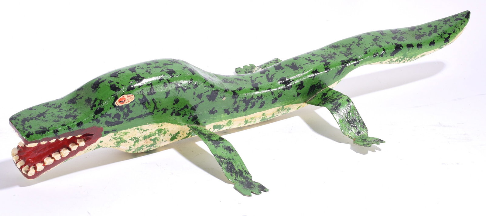 Tim Lewis Carved Wooden Alligator: 25"x4" Tim Lewis (born 1952) carved and painted wooden alligator with elongated green body, black markings, articulated-looking legs and an open mouth filled with individually modeled teeth. Eastern K