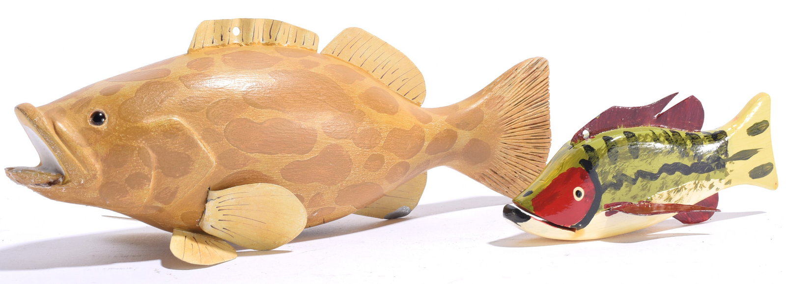 Two Wooden Carved Fish Decoys Signed: Largest is 8"x3" Two signed carved and painted wooden fish decoys, including a large natural-finish fish with carved fins and spotted decoration and a smaller brightly painted green, yellow and red fi