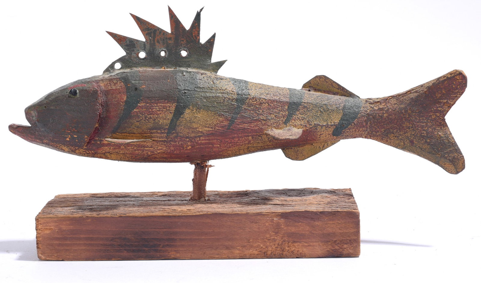 Bryce Ritter Carved Fish Decoy and Stand: 8"x5" Carved and painted fish decoy by Bryce Ritter displayed on a rustic wooden stand. The fish has a weathered painted surface in earthy red, brown and black tones, applied metal dorsal fin and a st