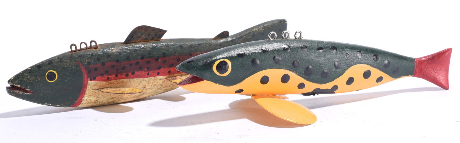 Vintage Carved Fish Decoys (2): Both about 7"x2" Pair of carved and painted wooden fish decoys in dark green and yellow tones, each with applied metal fins and hanging loops. One retains a notably aged surface while the other featur