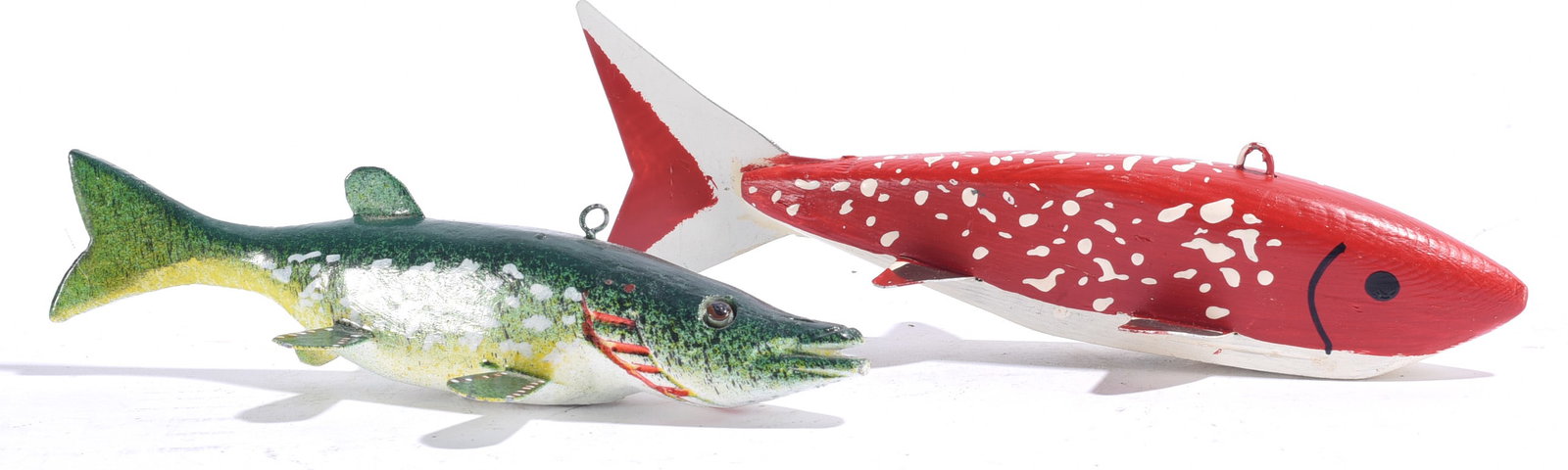 Vintage Carved Fish Decoys (2): Both 6"x1" Pair of carved and painted wooden fish decoys, including a green and white naturalistic fish and a bold red example with white spotted decoration. Both fitted with hanging loops.