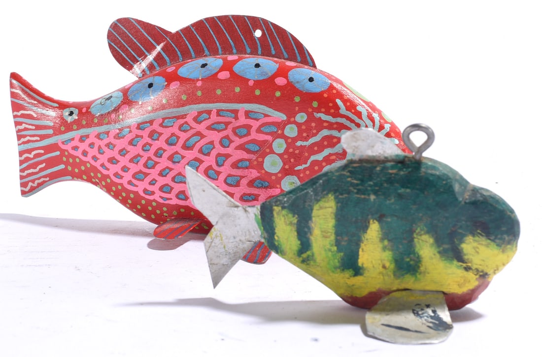 Katy Foster Carved Fish Decoy and other: Largest is 6"x3" Pair of carved and painted folk art fish decoys, including a highly decorated red fish with blue and pink patterning and a smaller green and yellow fish with metal fins and hanging lo