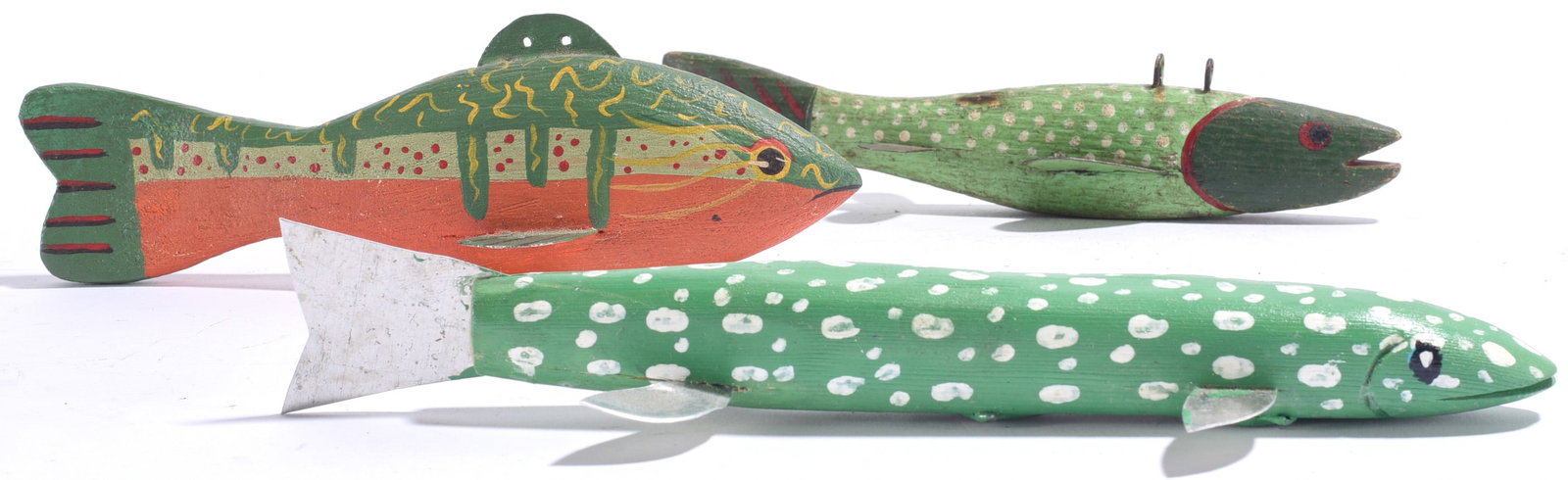 Vintage Carved Fish Decoys (3): Largest is 8"x1" Group of three vintage carved and painted wooden fish decoys in green, yellow, orange and black tones, each with individual painted decoration and applied fins.