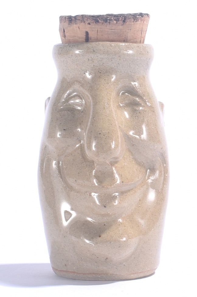 Folk Pottery Vase: 4" Folk pottery vase or bottle with light alkaline-style glaze and molded sculptural face featuring prominent nose, eyes, cheeks and smiling mouth. Fitted with a cork stopper.