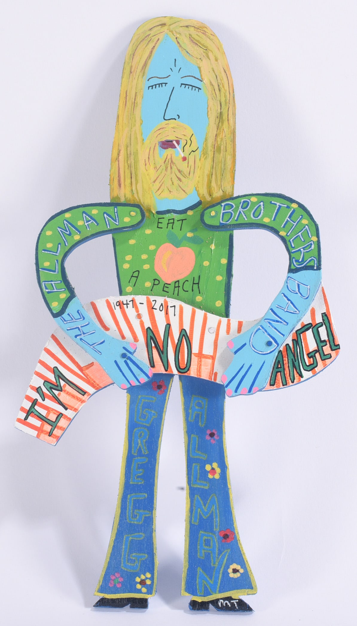 Miz Thang Folk Art Cutout and Paint: 12"x7" Miz Thang folk art painted cutout depicting Gregg Allman with long blond hair and colorful clothing. Hand-painted wood construction with lettering incorporated throughout the figure.
