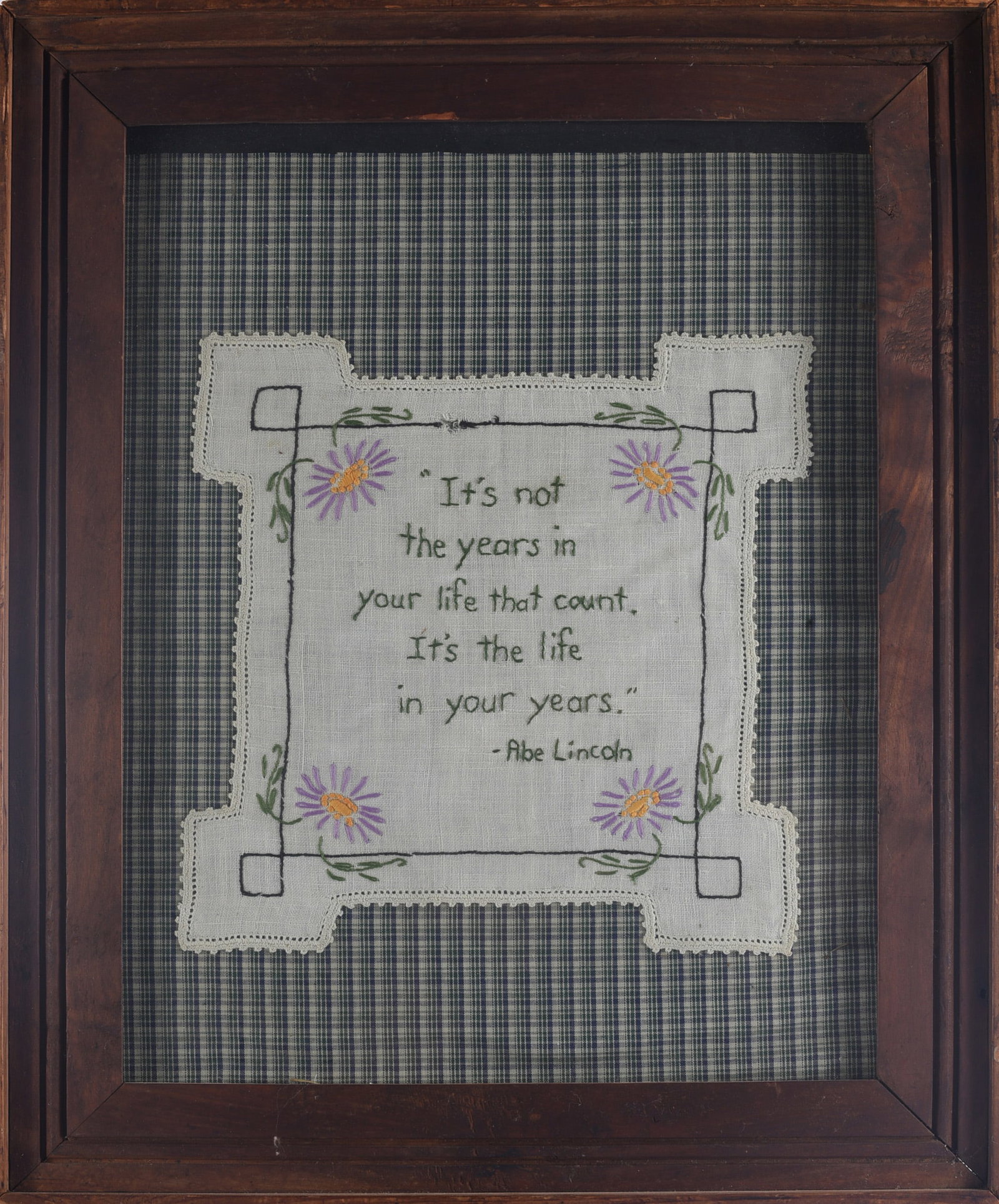 Needle Work Quote of Abe Lincoln: 18"x23" Embroidered needlework featuring a quote attributed to Abraham Lincoln, decorated with floral motifs and mounted against plaid fabric in a dark wooden frame.