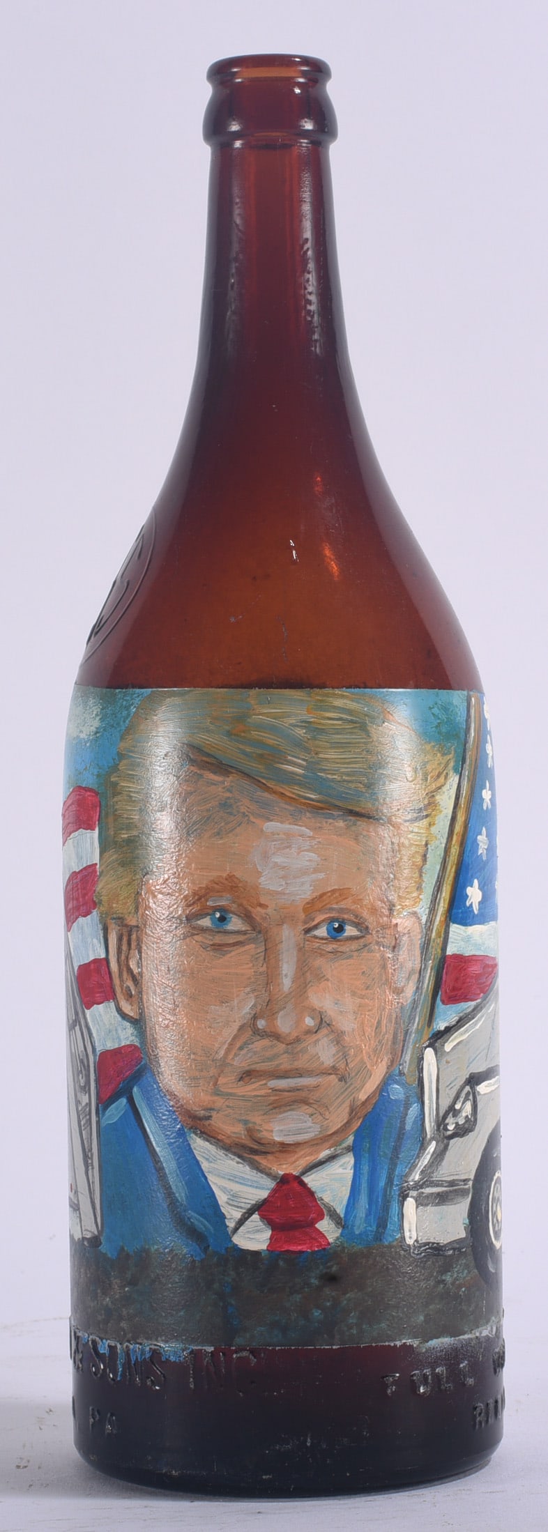 Richard Roebuck Painted Presidential Bottle: 12" Painted presidential bottle by Alabama folk artist Richard E. Roebuck (born 1960), featuring a hand-painted portrait of Donald Trump surrounded by patriotic imagery including American flags.