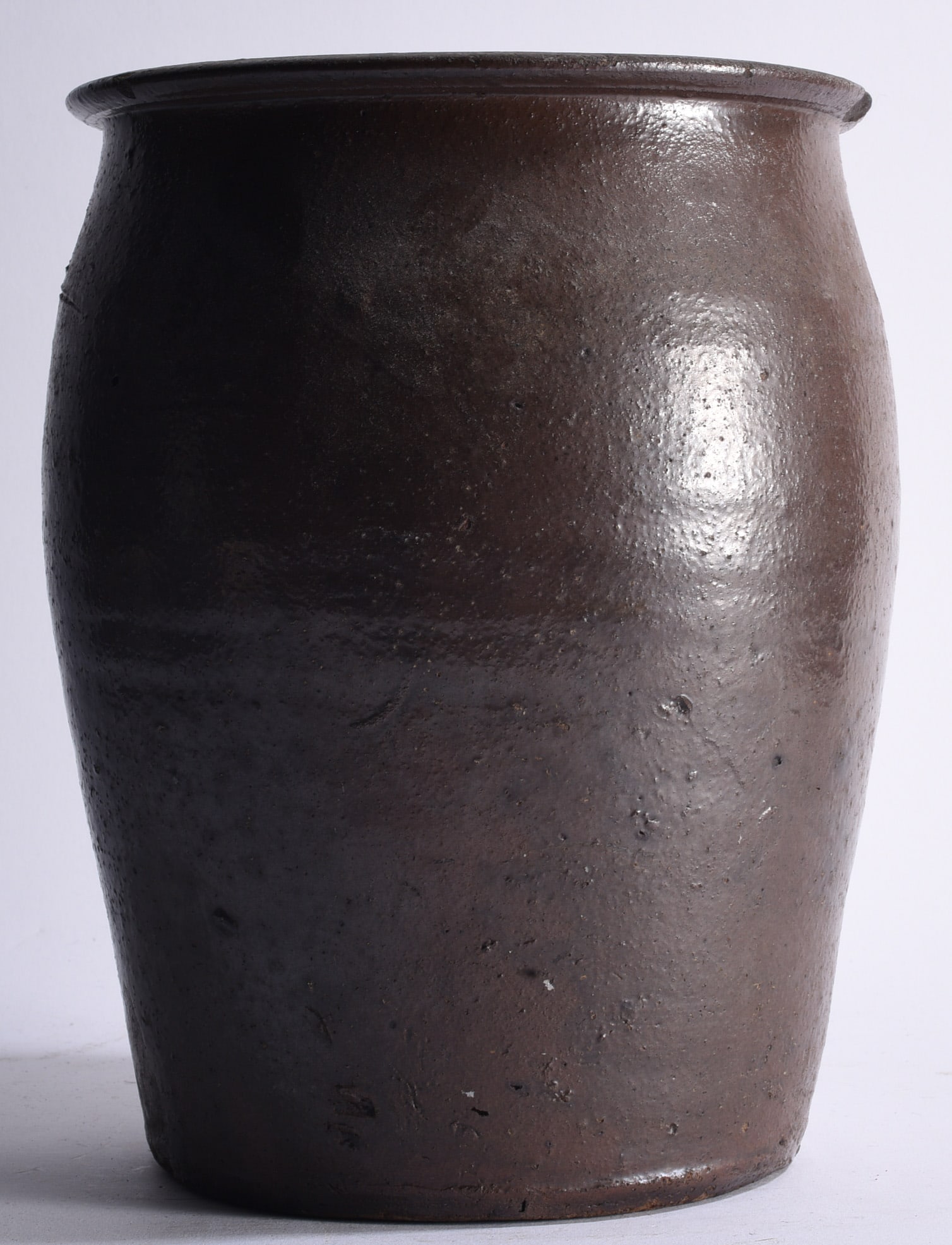 Piedmont North Carolina Pottery Jar ca. 1860: 11" Important circa 1860 Piedmont North Carolina stoneware storage jar of tall ovoid form with gently flared rim and dark brown alkaline glaze. The surface displays attractive kiln texture, glaze vari