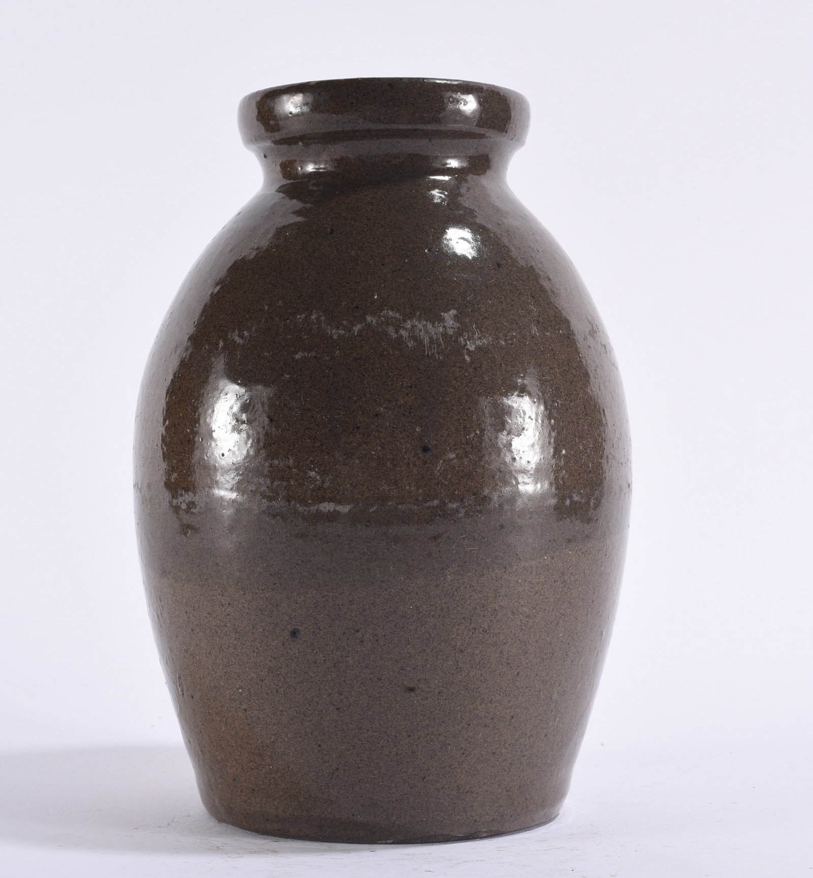 Antique Southern Alkaline Glazed Stoneware Jar: 9" Antique Southern stoneware storage jar of ovoid form with heavy rolled rim and dark brown to alkaline-type glazed surface. Wheel-thrown construction with attractive glaze variation, firing marks an