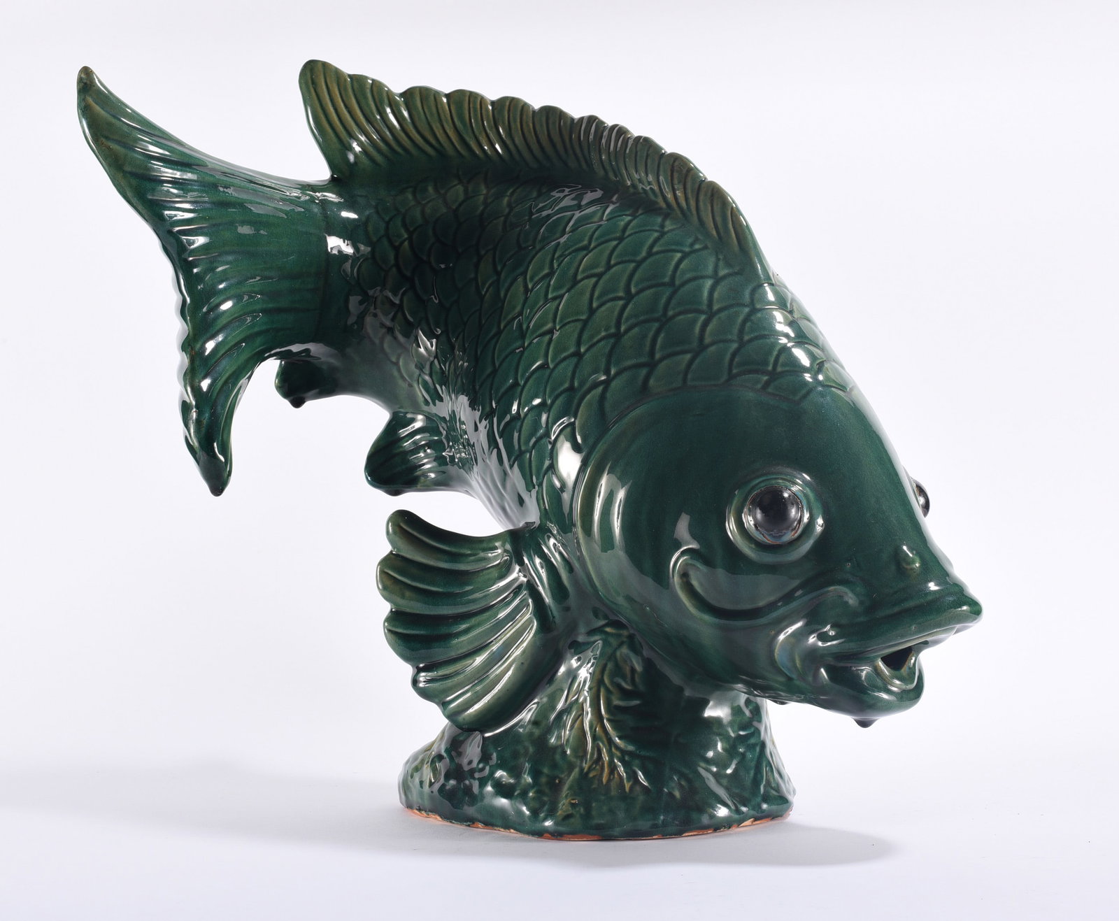 Large Green Glazed Ceramic Fish Sculpture: 19"x20" Large figural ceramic fish sculpture covered in a rich dark green glaze. Highly modeled body with raised scales, prominent fins, open mouth and applied glass-like eyes. Dramatic decorative pot