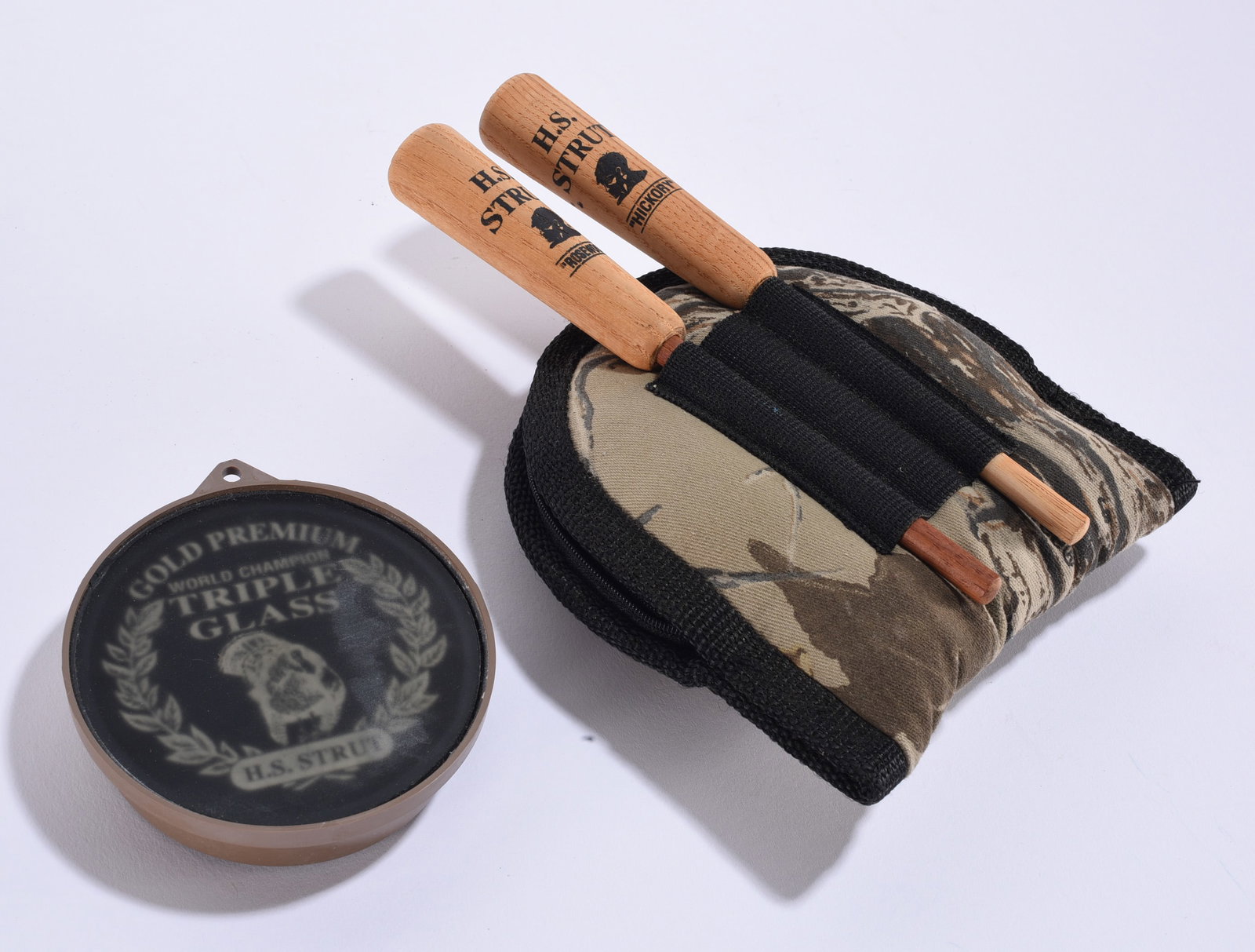 H.S. Strut Turkey Calling Set with Triple Glass Call: 8"x6" H.S. Strut turkey calling group including a "Gold Premium World Champion Triple Glass" friction call and two H.S. Strut Hickory striker-type calls housed in a camouflage carrying case. Purpose-b