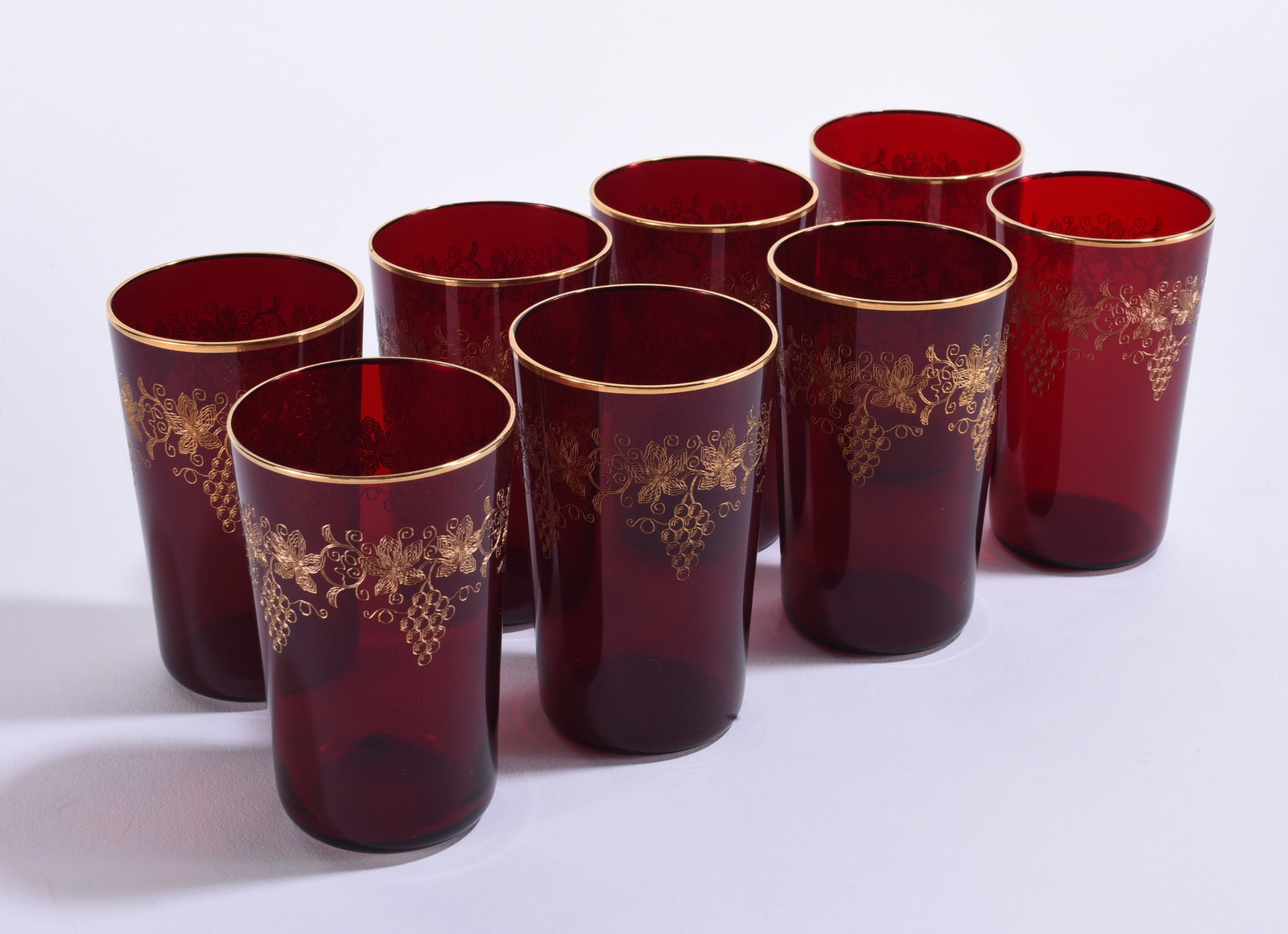 Set of Eight Ruby Red Glass Tumblers with Gold Grape Decoration: 5" each Set of eight ruby red glass tumblers decorated with gilt grapevine, leaf and grape-cluster designs and gilt rims. Rich translucent ruby coloring with elegant gold decoration. Attractive mid-ce