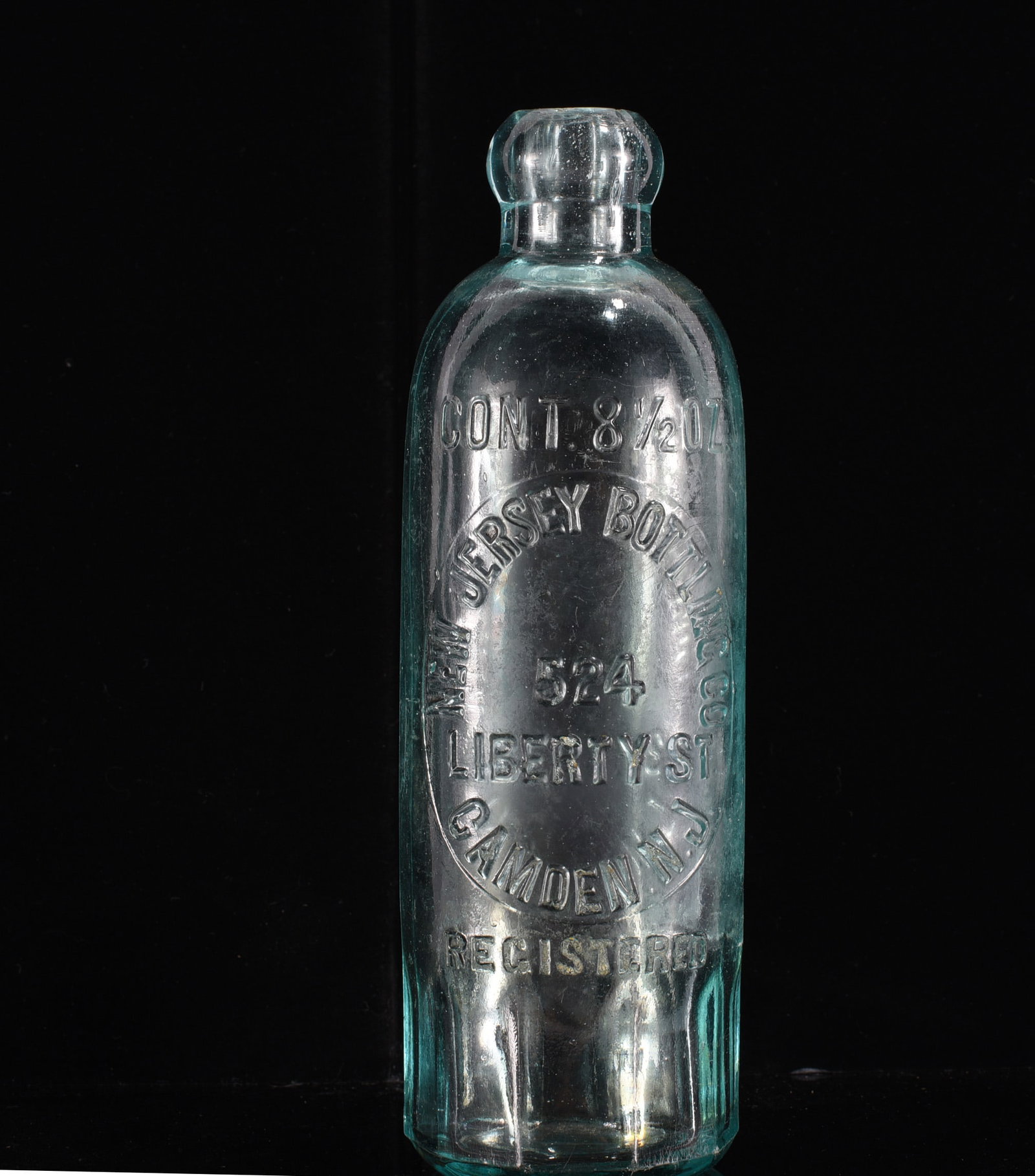New Jersey Bottling Co. Camden NJ Hutchinson Soda Bottle: 7" Antique aqua glass Hutchinson soda bottle embossed "New Jersey Bottling Co. / 524 Liberty St. / Camden, N.J. / Registered," with "Cont. 8½ Oz." above. Heavy glass construction with blob top.