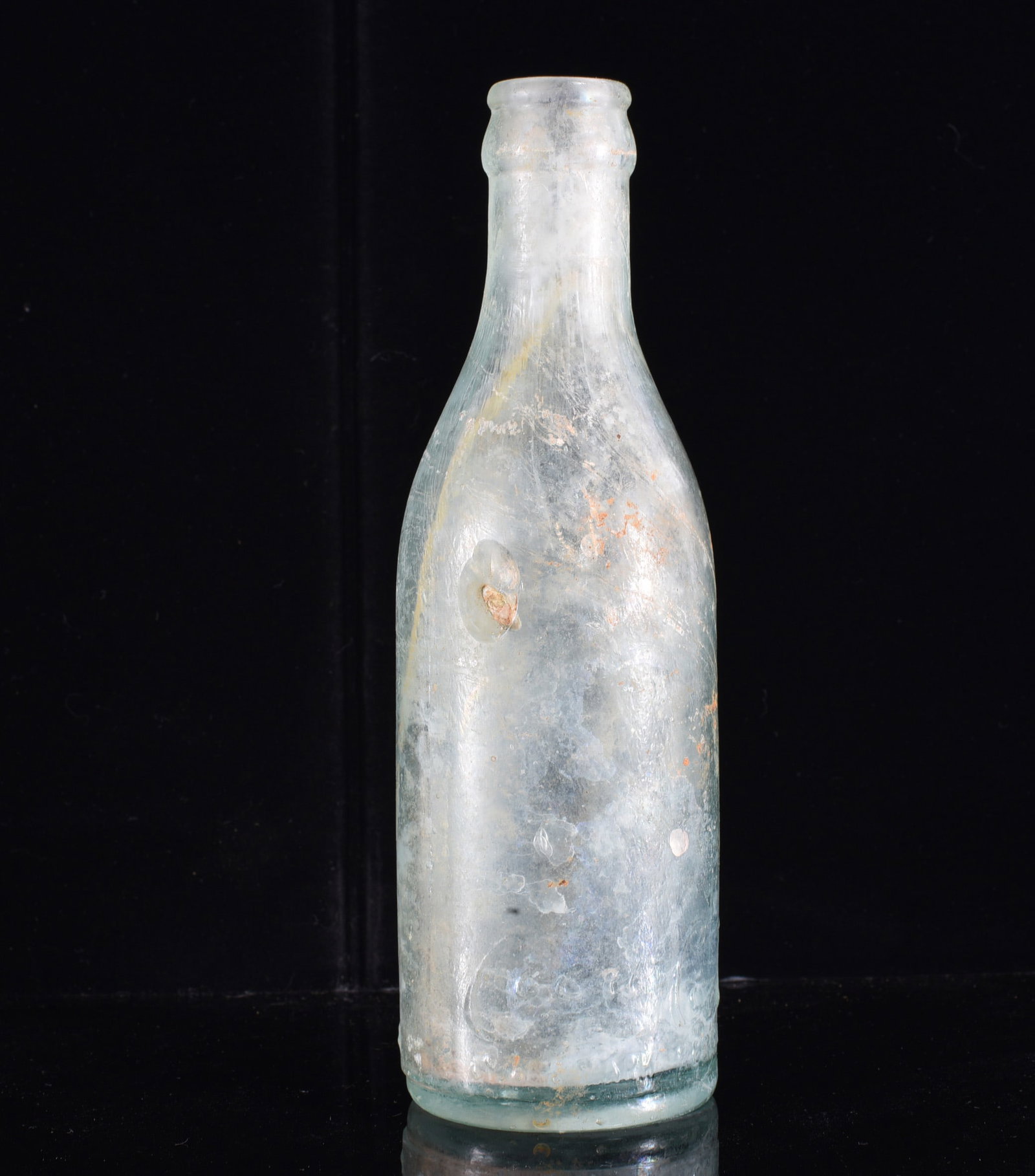 Antique Unmarked Aqua Glass Blob Top Bottle: 7" Antique aqua glass bottle of tall cylindrical form with rounded shoulder and applied lip. No prominent embossing is visible from the photograph. Displays considerable surface haze, staining and age