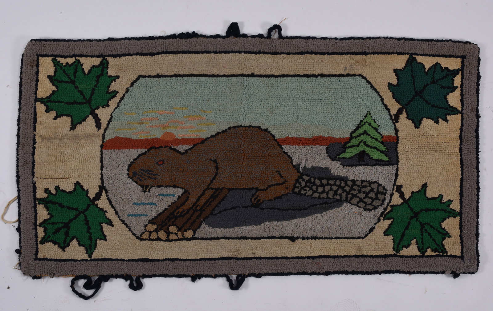 Folk Art Hooked Rug with Beaver & Maple Leaves: 36"x20" Large folk art hooked rug depicting a beaver beside a dam in a stylized northern landscape with setting sun, water and evergreen tree. Large green maple leaves decorate each corner. Worked in 