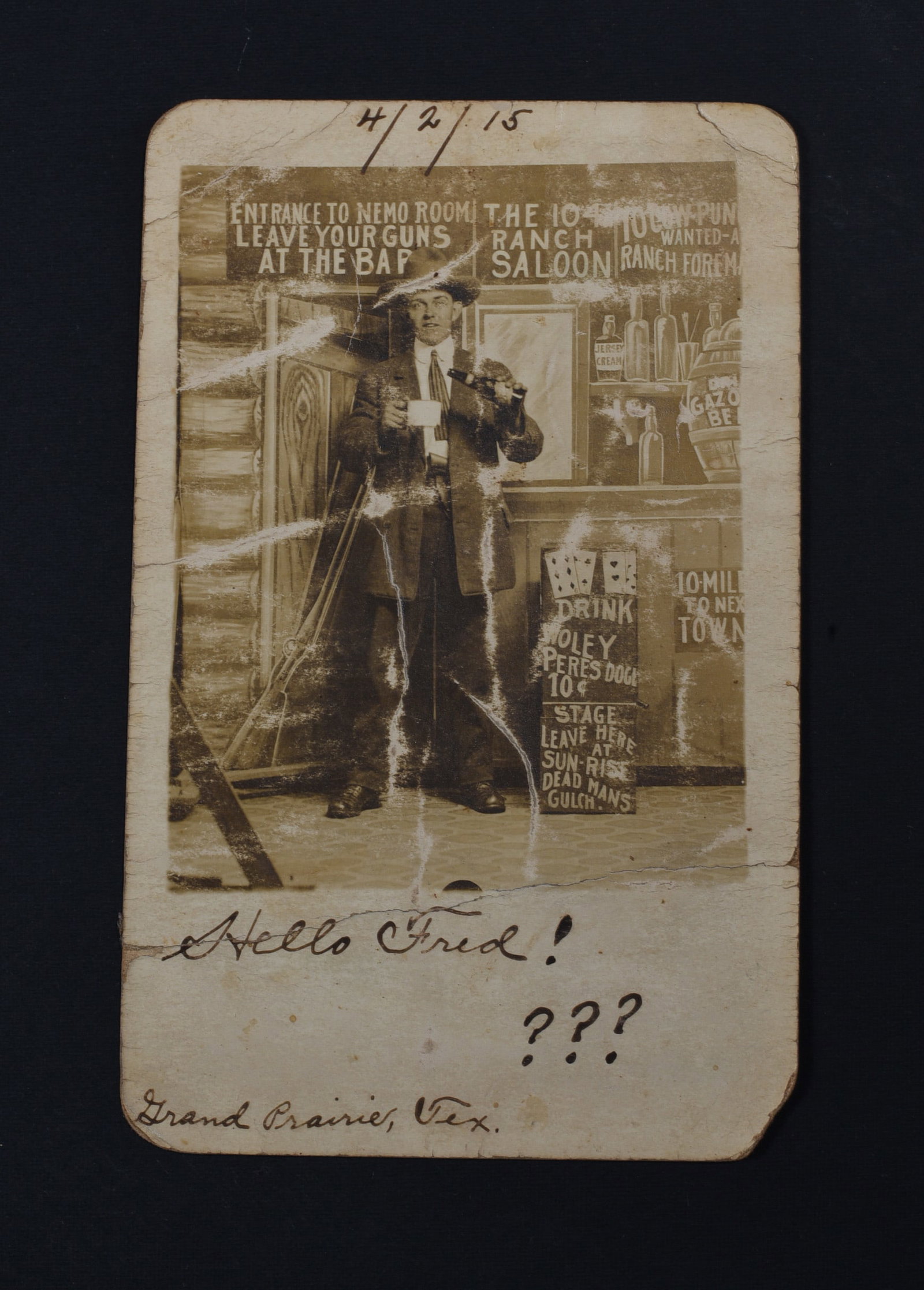 101 Ranch Saloon Photo: Real photo postcard of a gentleman in studio depicting a bar with “The 101 Ranch Saloon” above. Sender “R.F.D.” from Grand Prairie, Texas, says hello to his friend Fred Bruce of Crawfo