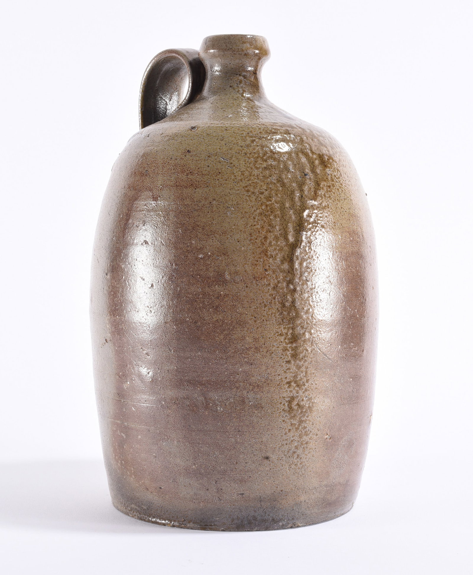 Salt Glaze Piedmont NC Jug ca. 1880: Piedmont North Carolina salt-glazed stoneware jug, circa 1880, of tall cylindrical form with rounded shoulder, short neck and applied strap handle. The surface displays a subdued gray-brown salt