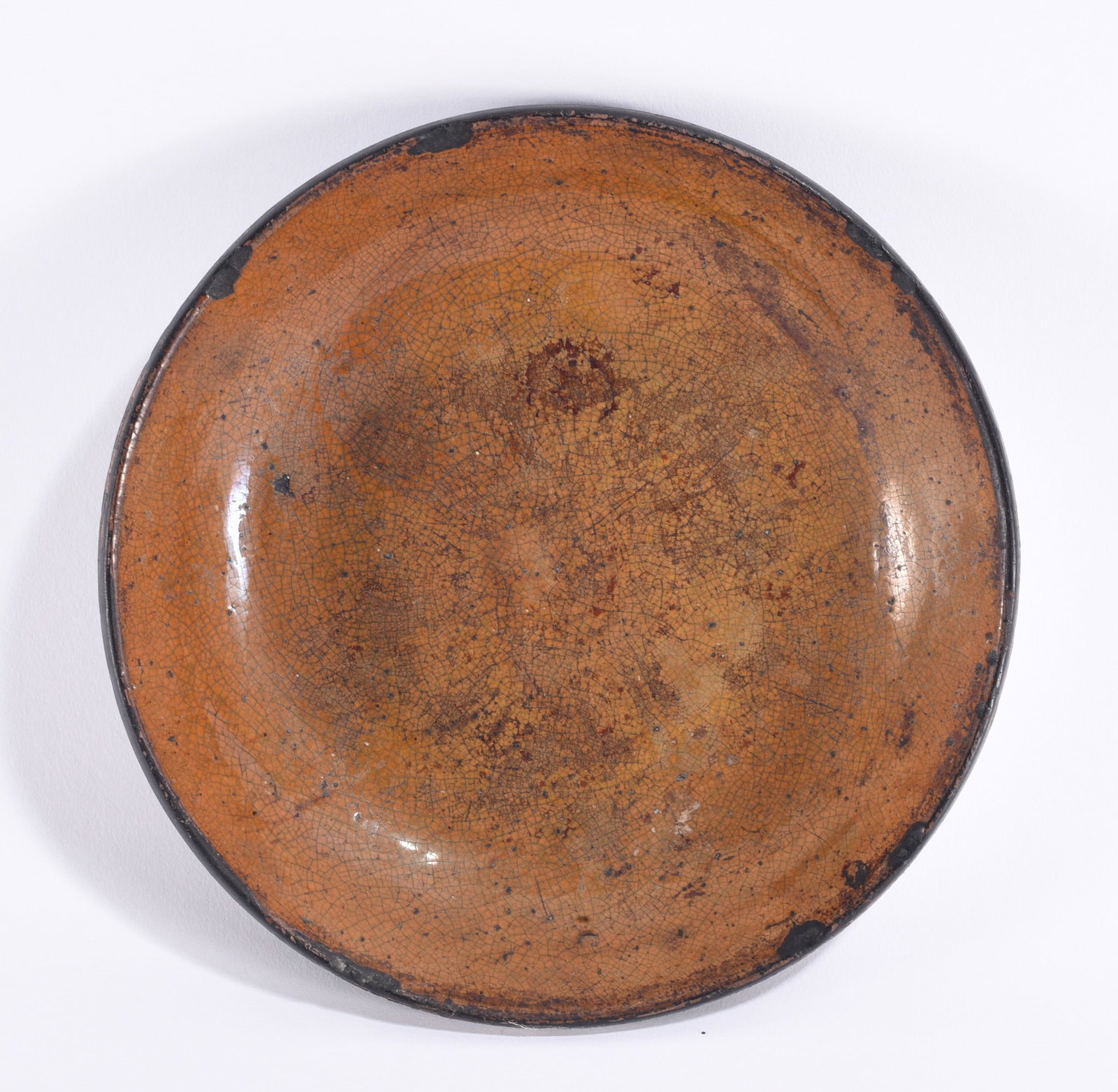 PA Pie Plate ca. 1870: Pennsylvania redware pie plate, circa 1870, of broad shallow circular form with a rolled darkened rim and warm orange-brown glazed interior. The surface displays extensive age-related crazing, firing