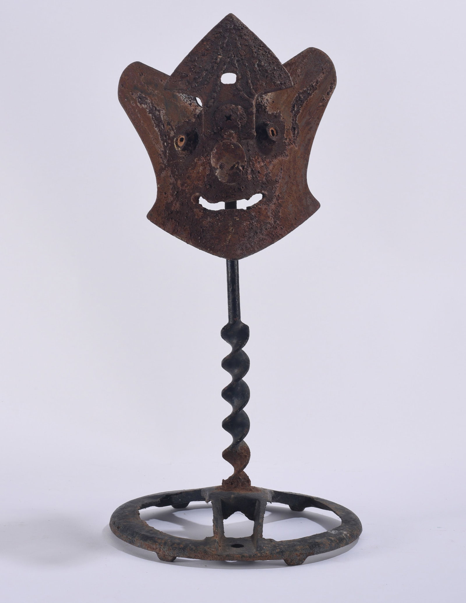 Mike Hutson Yard Art Sculpture: Mike Hutson folk art yard sculpture constructed from found and repurposed iron components, featuring a whimsical figural face mounted above a twisted metal shaft and circular base. The heavily weather