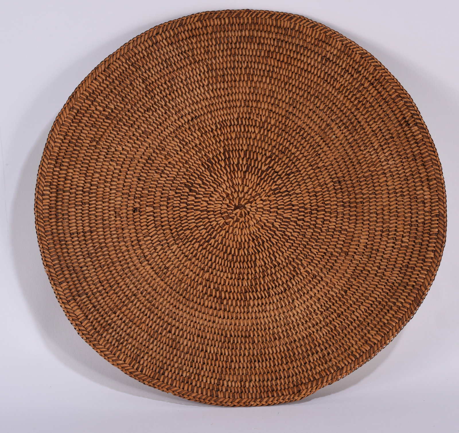 Sweet Grass Basket: Finely woven sweetgrass basket or tray of broad circular form, worked in tightly concentric coils with a neatly finished outer rim. The warm natural coloration and exceptionally dense, even weave emph