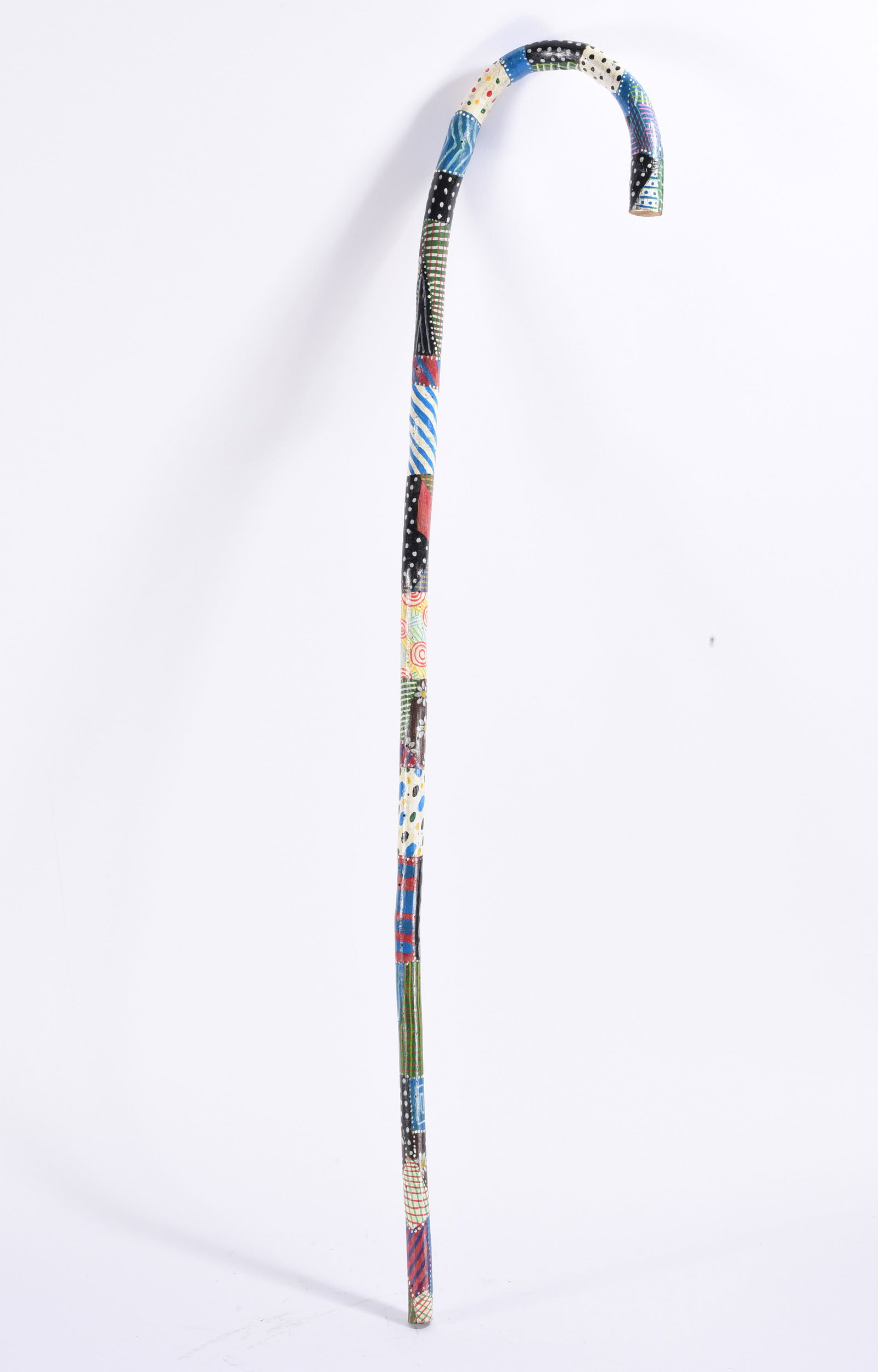 Richard Roebuck Folk Art Painted Cane Walking Stick: Hand-painted folk art crook-handle walking stick by Richard Roebuck, decorated from top to bottom with an assortment of colorful geometric patterns. Alternating sections incorporate dots, stripes, che