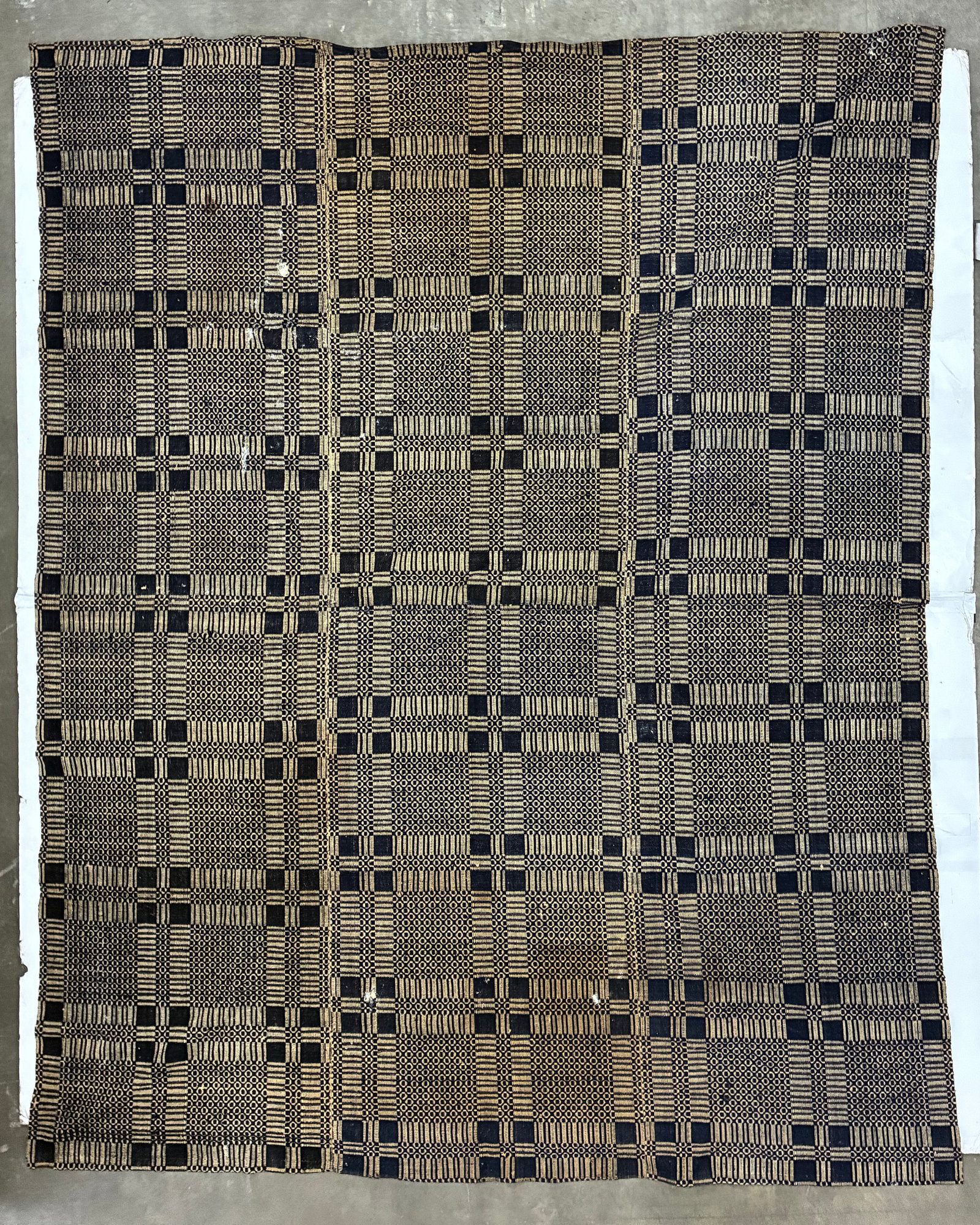 Early American Black & Cream Geometric Handwoven Coverlet: 102"x89" Early American handwoven coverlet featuring an allover black or very dark indigo and cream geometric pattern. Alternating woven structures create a large plaid-like grid filled with small