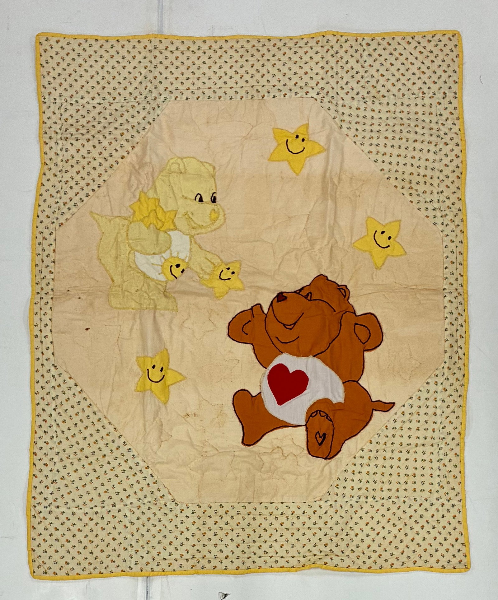 American Care Bears Appliqué Child's Quilt: 35"x44" American child's appliqué quilt featuring large cartoon bear figures and smiling yellow stars arranged against a pale central ground. One brown bear with a red heart belly emblem dominates th