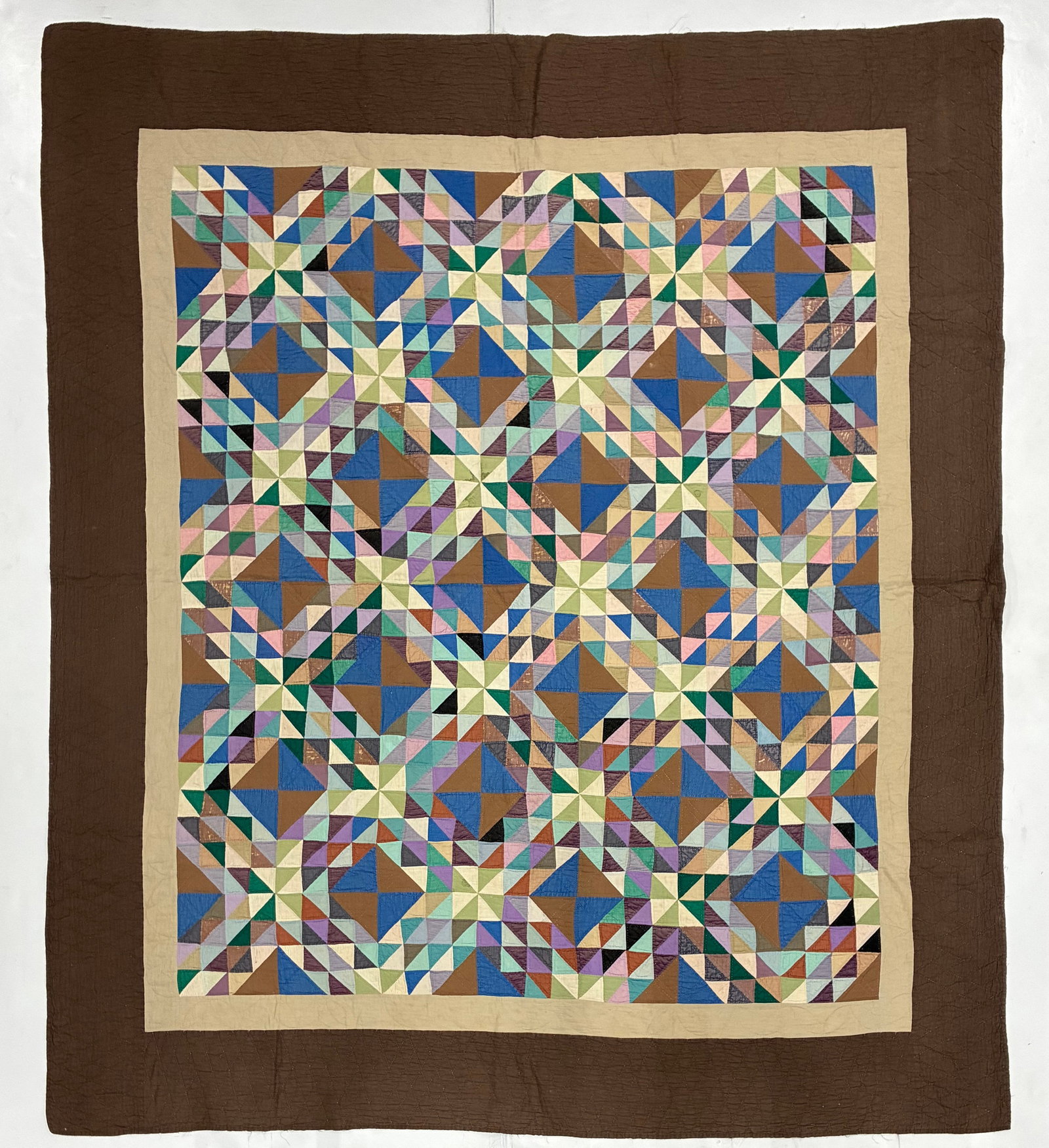 American Geometric Star & Pinwheel Quilt with Brown Border: 78"x83" American geometric quilt featuring a complex repeating arrangement of stars, pinwheels, diamonds and triangular pieces in blue, green, lavender, pink, cream, brown and black. Numerous small