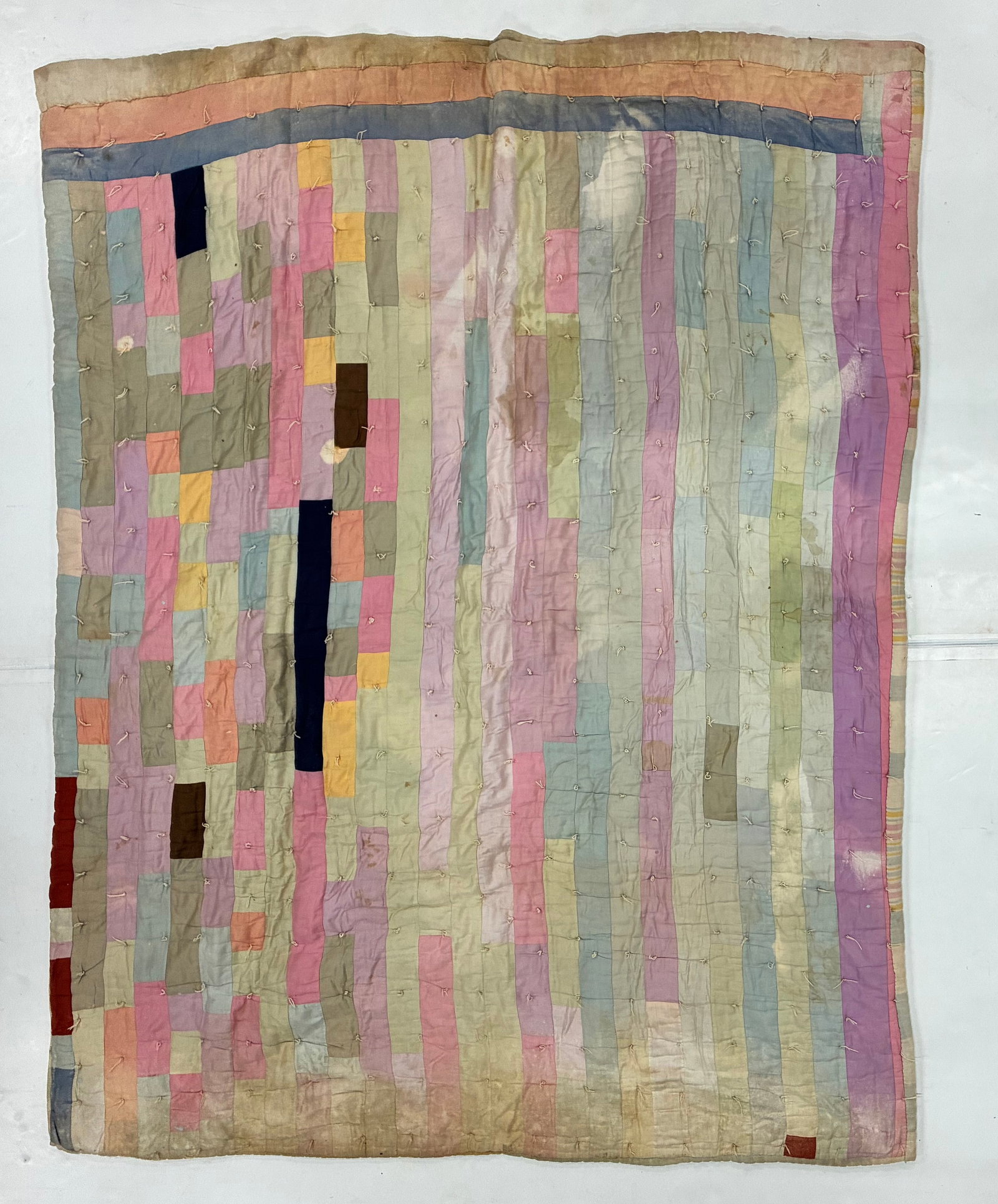 American Pastel Improvisational Strip Tied Utility Quilt: 78"x62" American improvisational tied utility quilt constructed from narrow vertical strips and irregular rectangular patches in soft pink, lavender, pale blue, gray, cream, yellow and muted green.