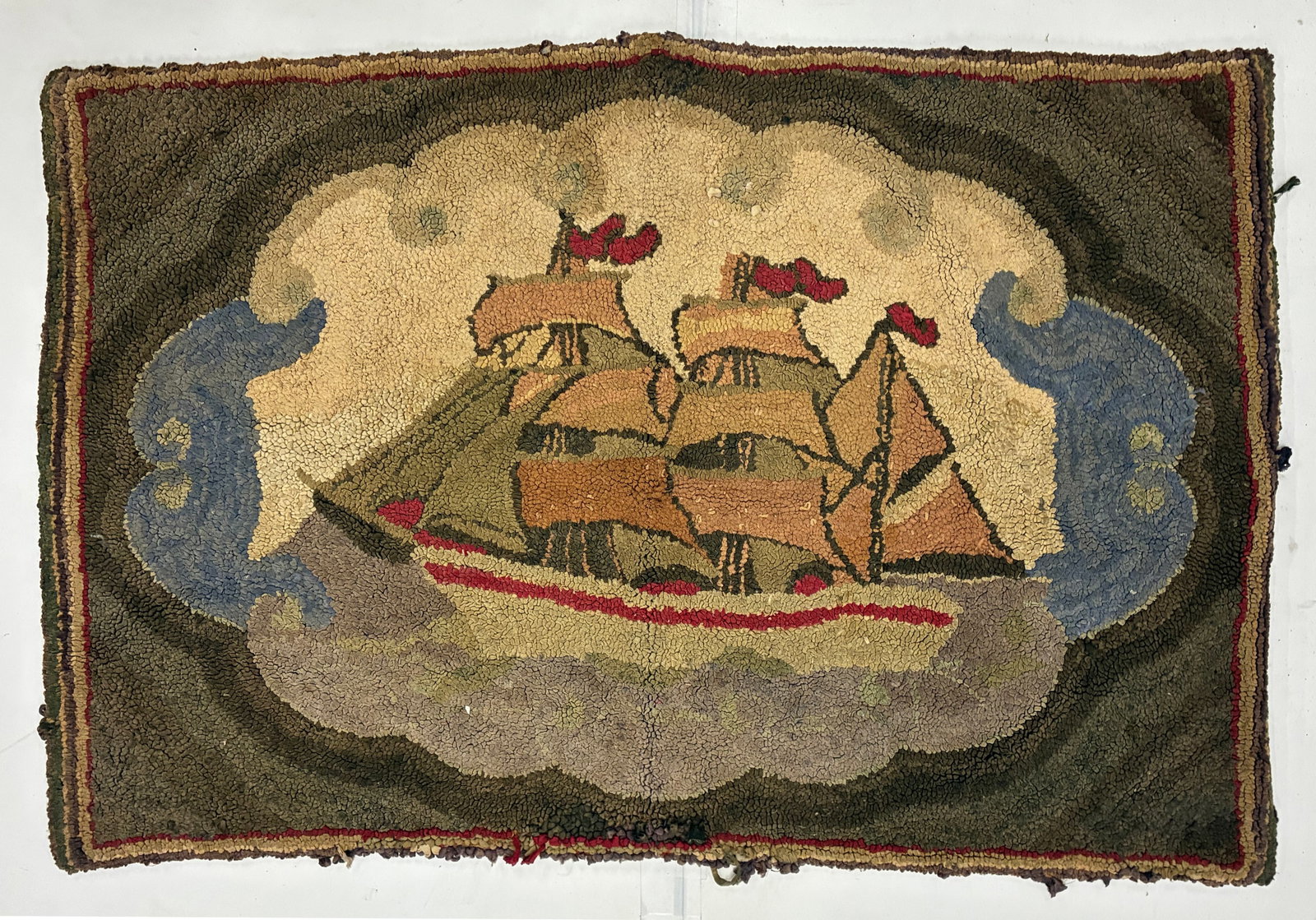 Vintage Sailing Ship Folk Art Hooked Rug: 38"x25" Hand-hooked rug depicting a multi-masted sailing ship riding through stylized blue waves beneath large cream clouds. The vessel is worked in muted tan, brown, green and red against a dark