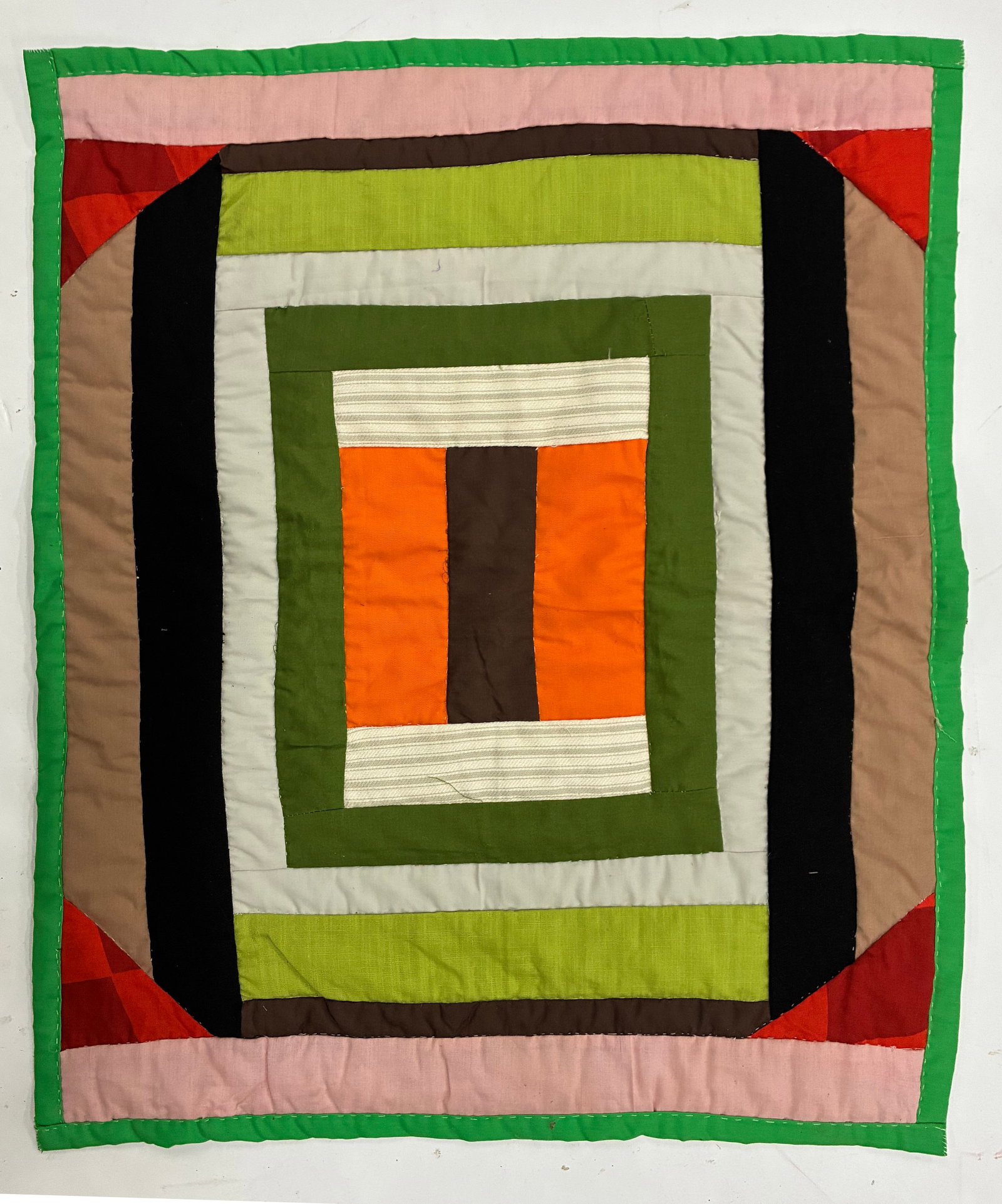Miniature Gees Bend Quilt with stamp: 26"x21" Handmade patchwork quilt constructed in a bold concentric frame design with a central orange and brown panel surrounded by bands of green, cream, black, tan, lime, pink and red. Strong