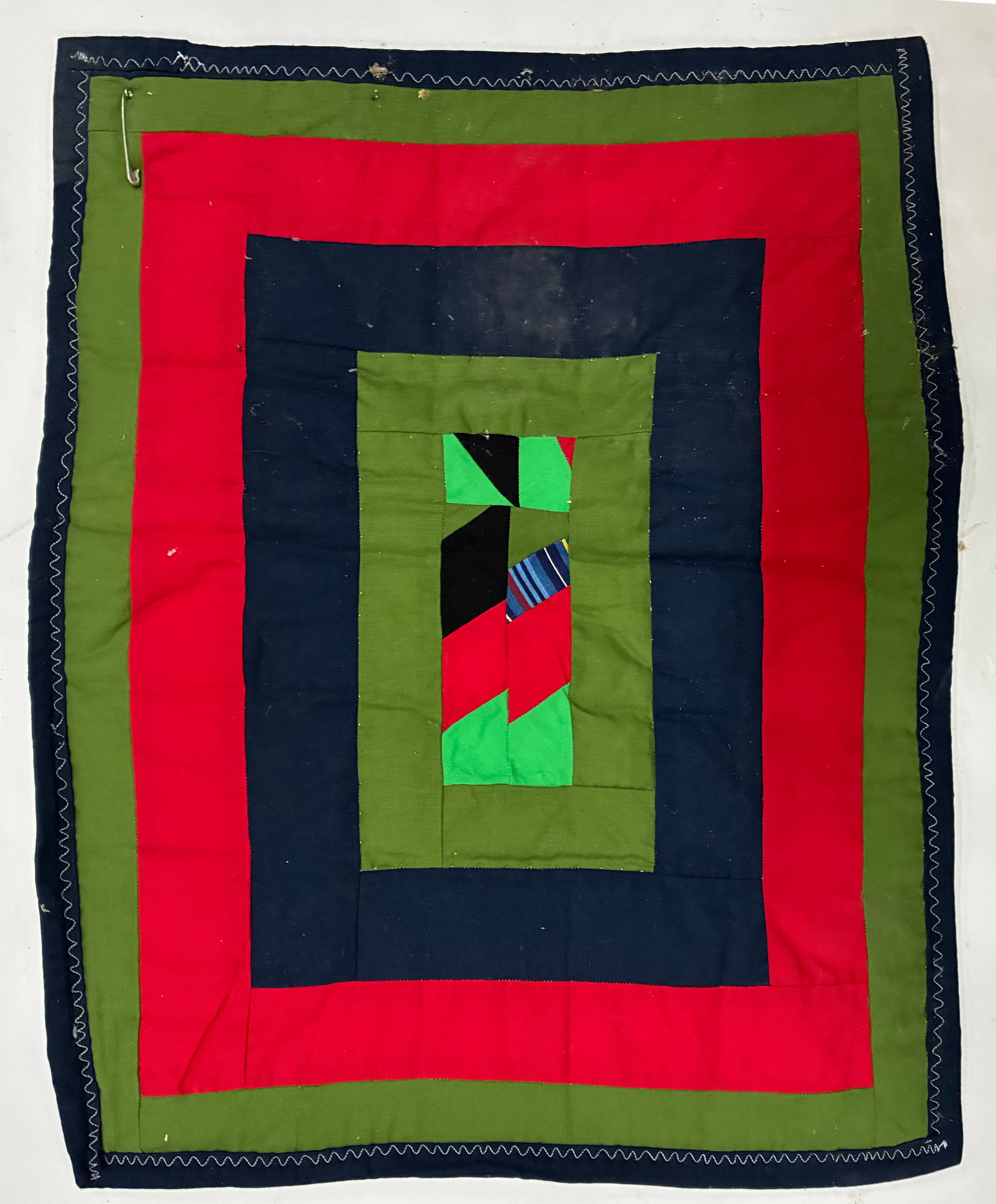 Miniature Gees Bend Quilt with stamp: 23"x19" Handmade folk art quilt composed of broad concentric rectangular bands in vivid red, olive green and dark navy surrounding a small improvisational center of green, red, black, blue and