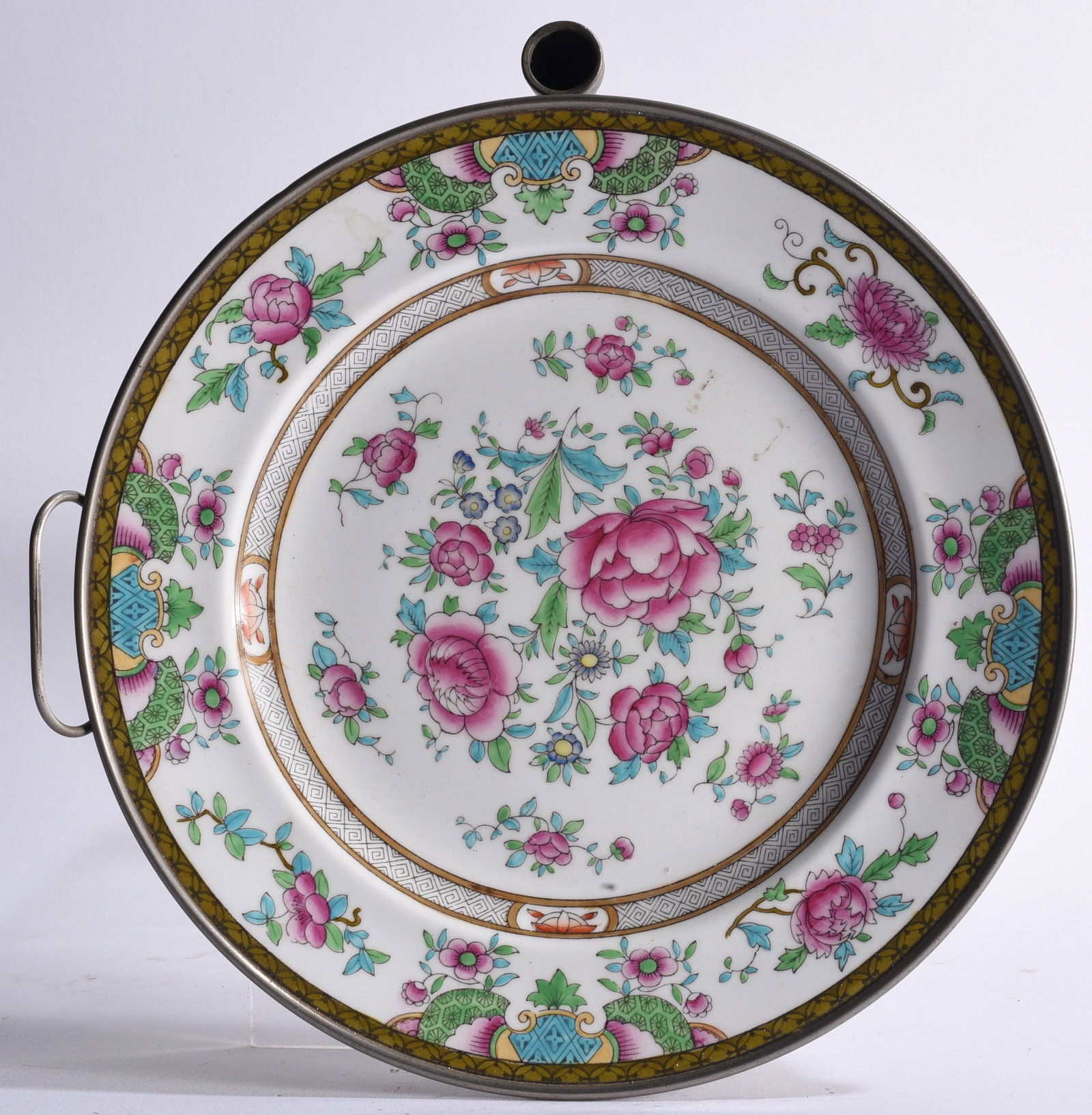 Chinese Export Rose Medallion Porcelain Warming Plate: 11" diameter Chinese export porcelain plate or warming dish decorated with colorful floral designs in pink, green, turquoise, blue and gilt. Mounted within a metal frame with side handle and upper fil