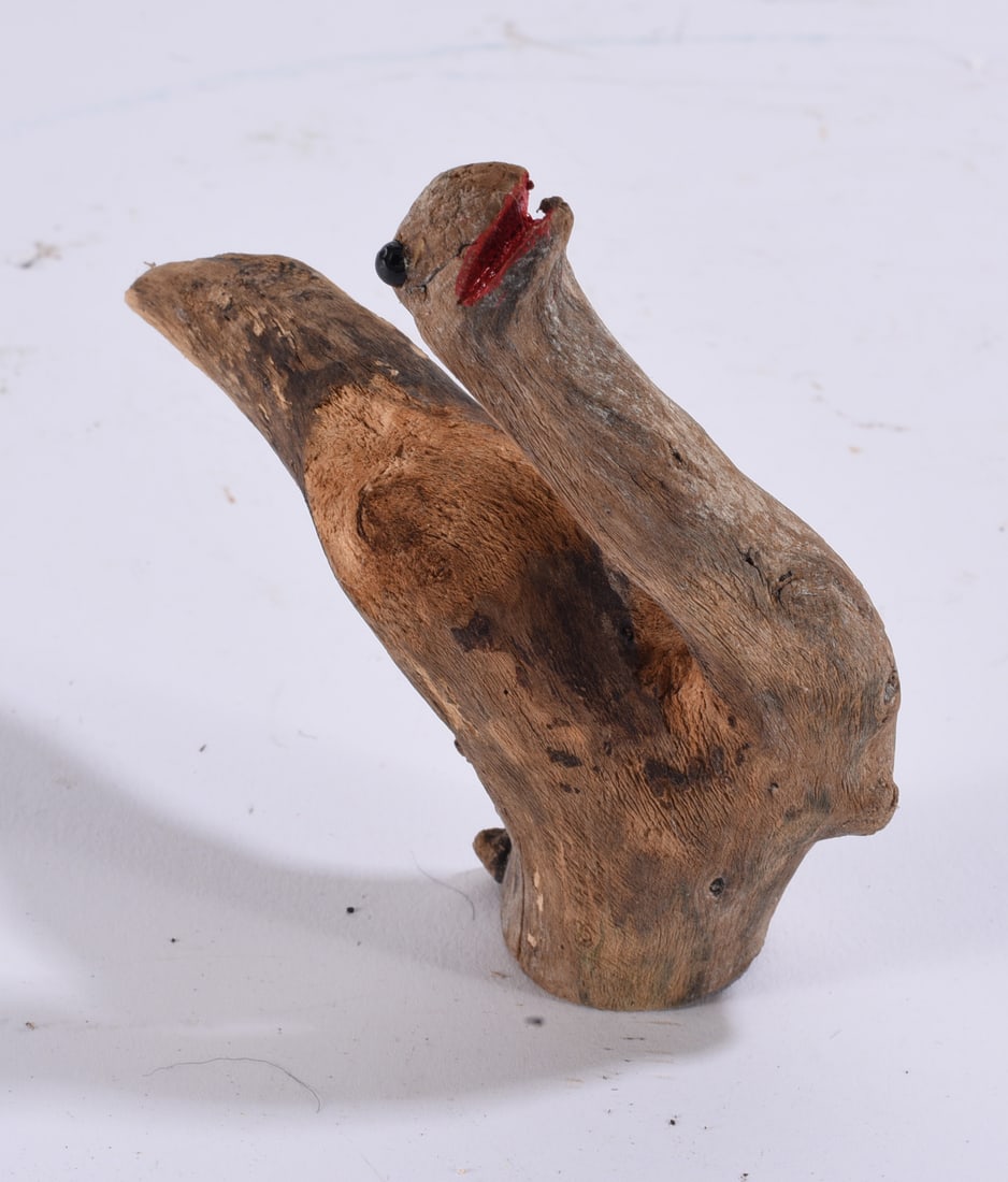 Primitive Folk Art Carved Wooden Bird: 5" Primitive folk art bird hand carved from a naturally shaped piece of wood, utilizing the original branch form to establish the body and tail. Features an applied dark eye and red-painted open beak.